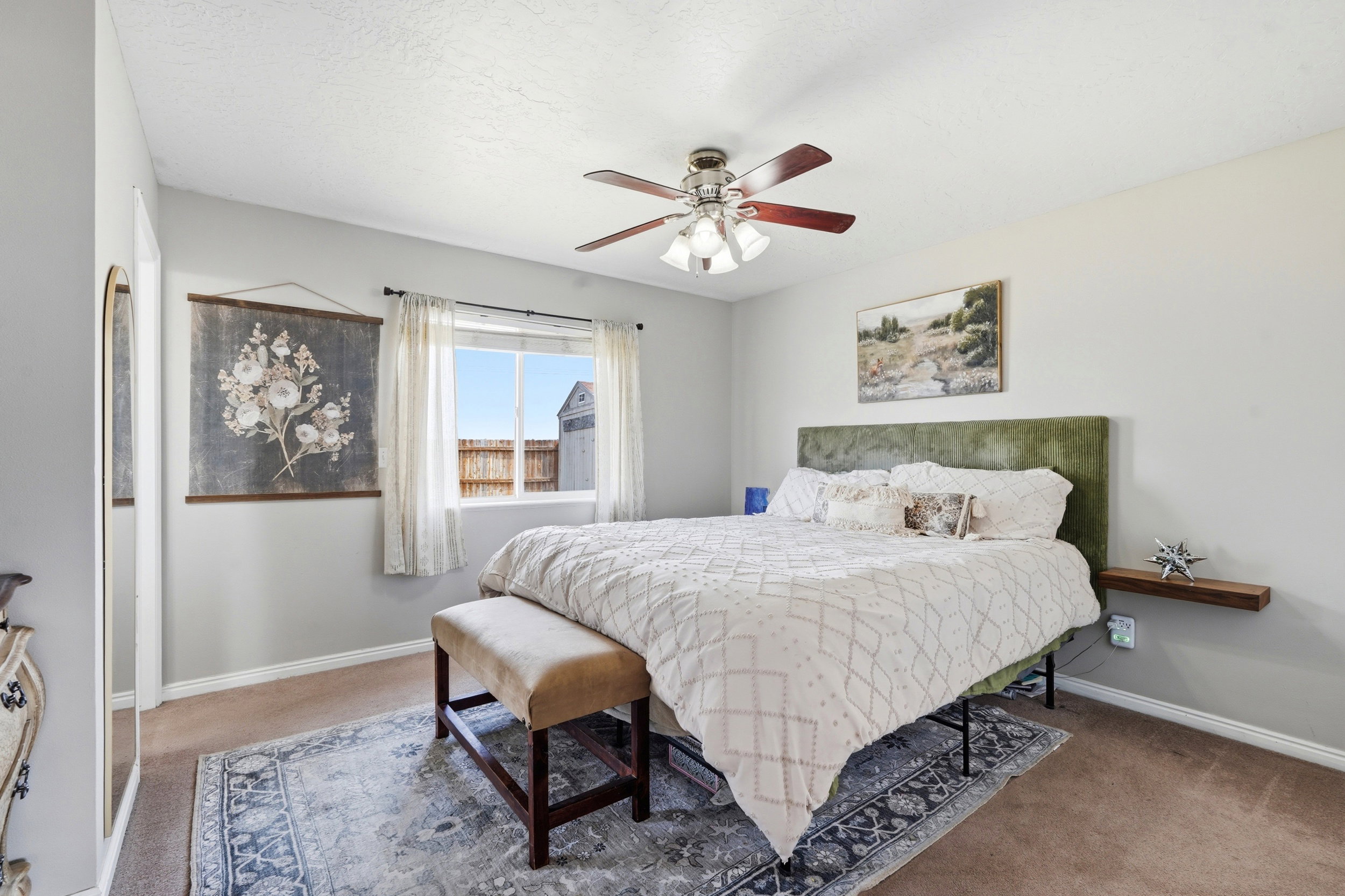 Bedroom featuring a ceiling fan with light fixture, window with curtains, and wall-to-wall carpeting