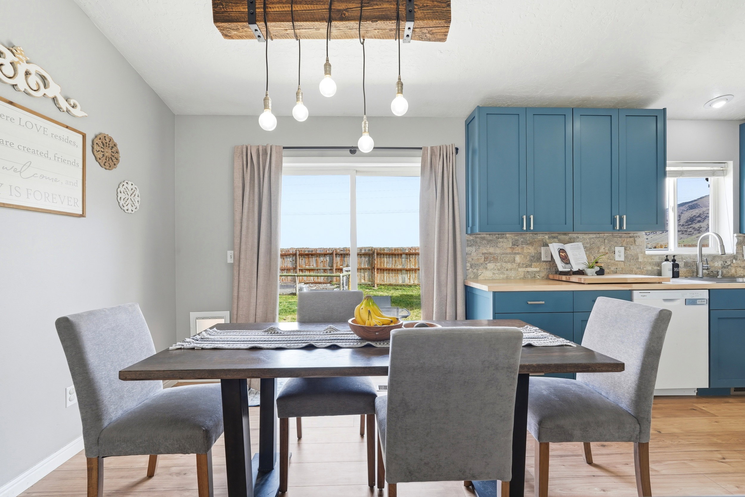 Dining area featuring a wood-finish table with a unique wood beam light fixture
