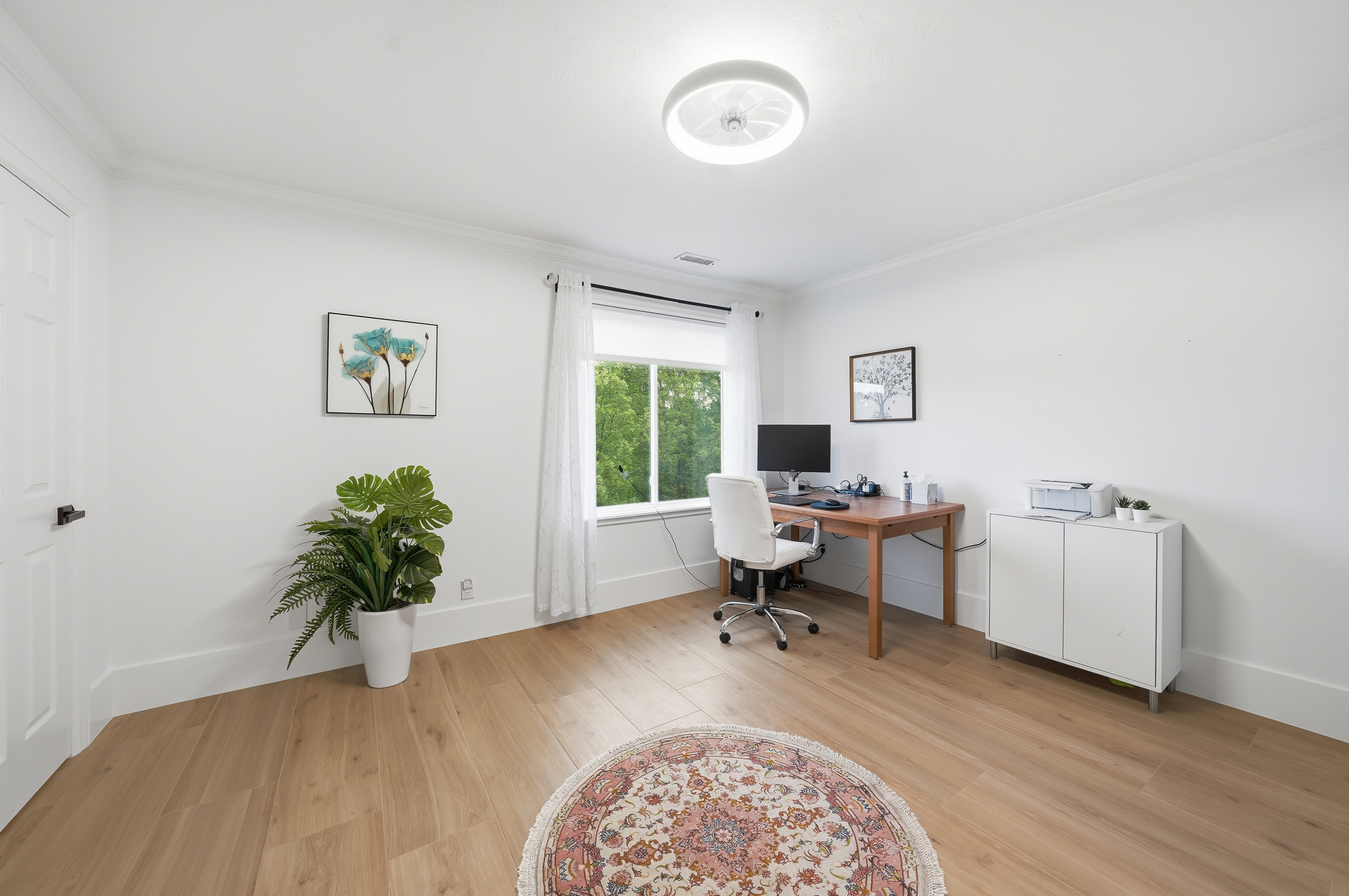 Bright room featuring light wood-finish flooring, crisp white walls, and a recessed window with natural light
