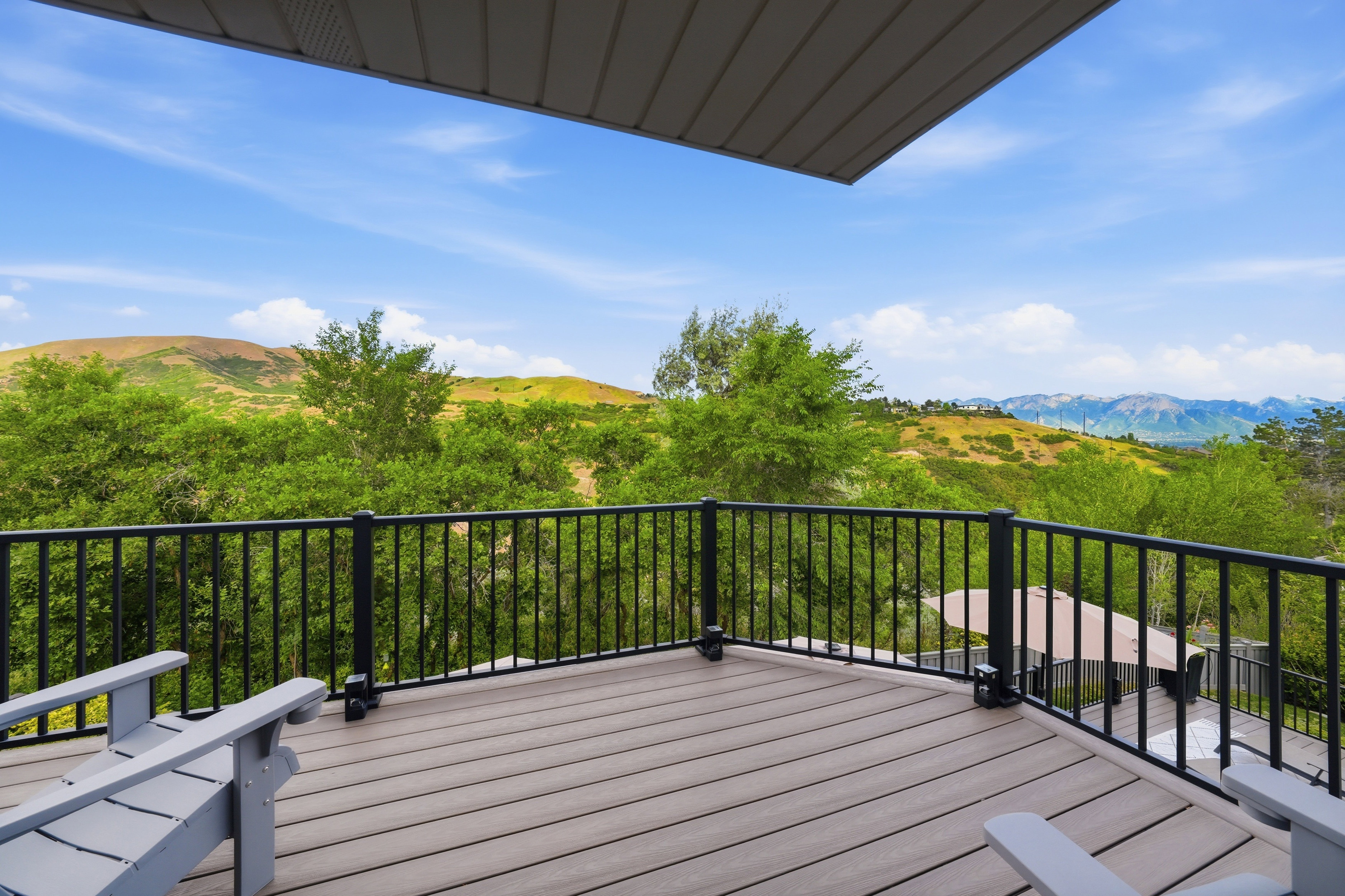 Spacious outdoor deck featuring composite decking and a black metal railing