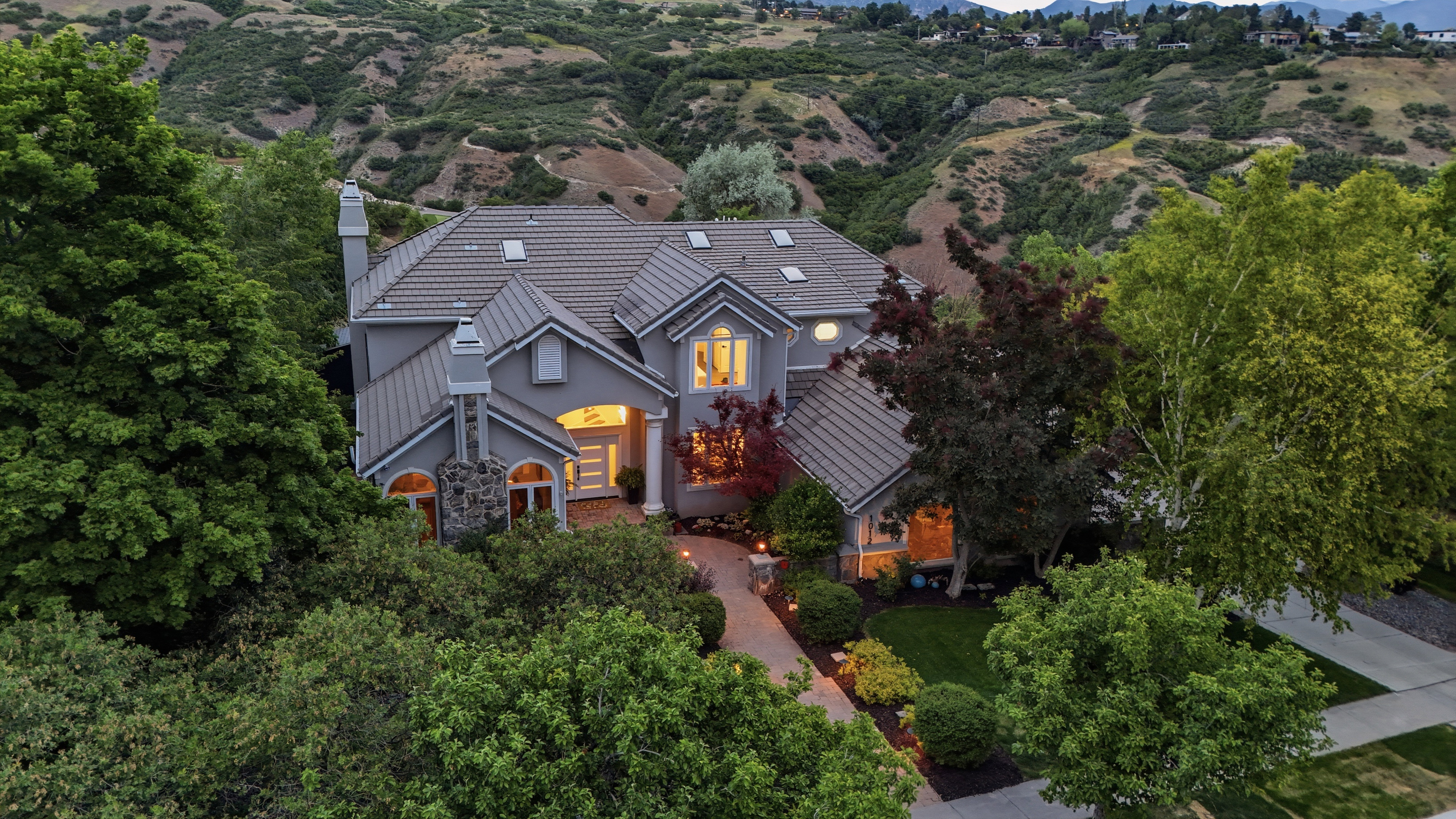 Stucco exterior residence with a multi-level tile roof and multiple chimneys