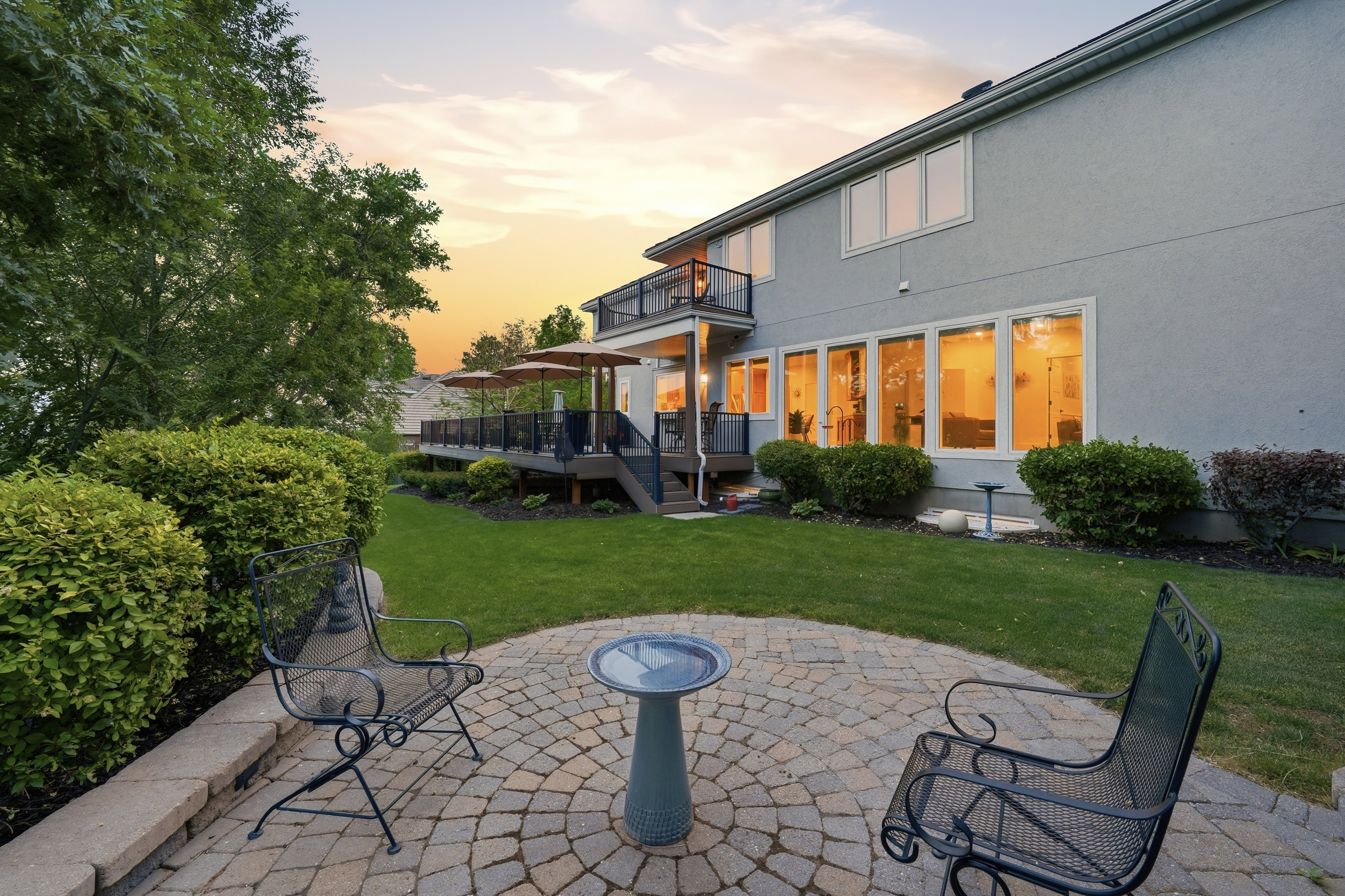 Paver patio with a circular pattern and stone retaining wall
