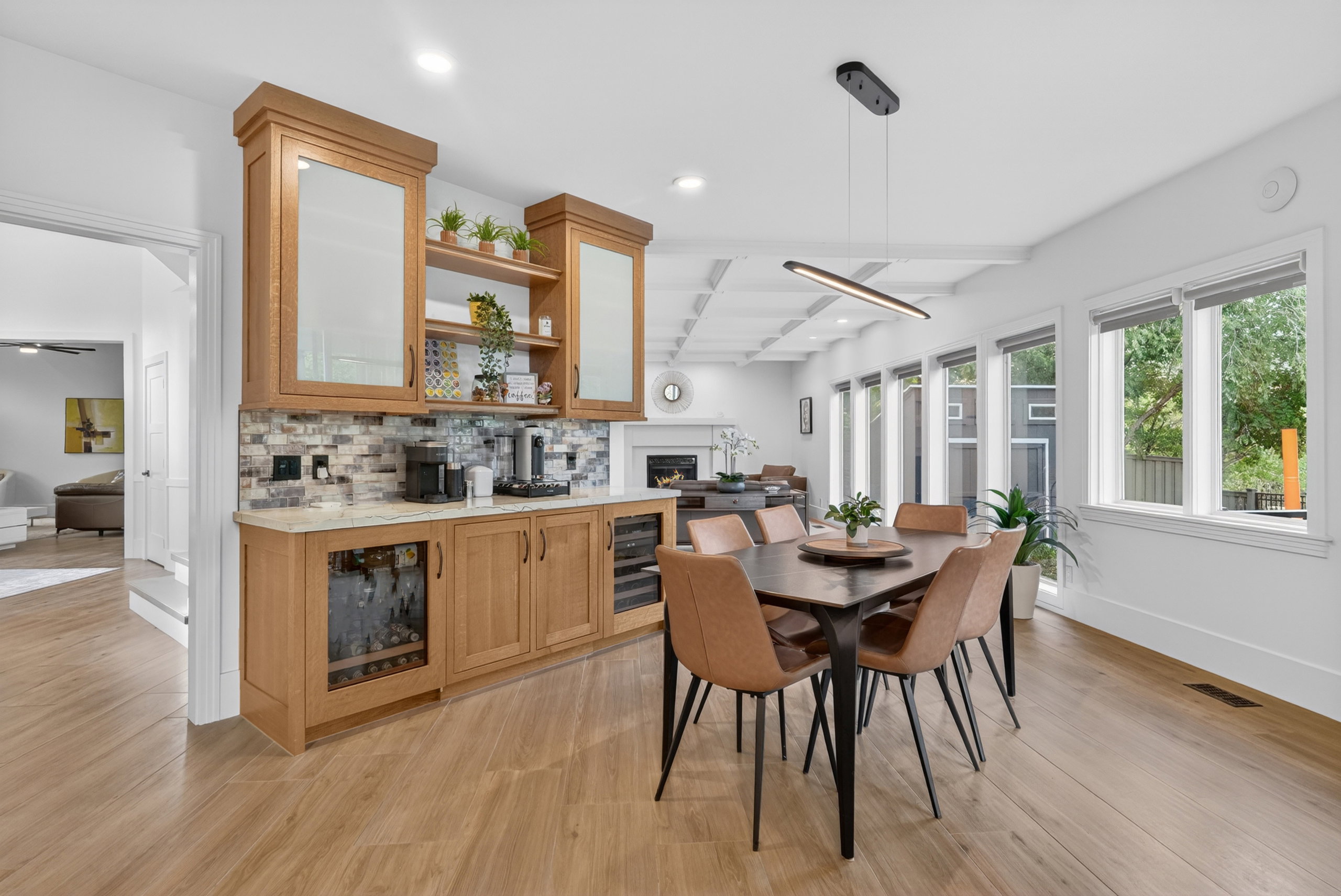 Integrated dining area featuring light wood-finish flooring and multiple windows providing natural light