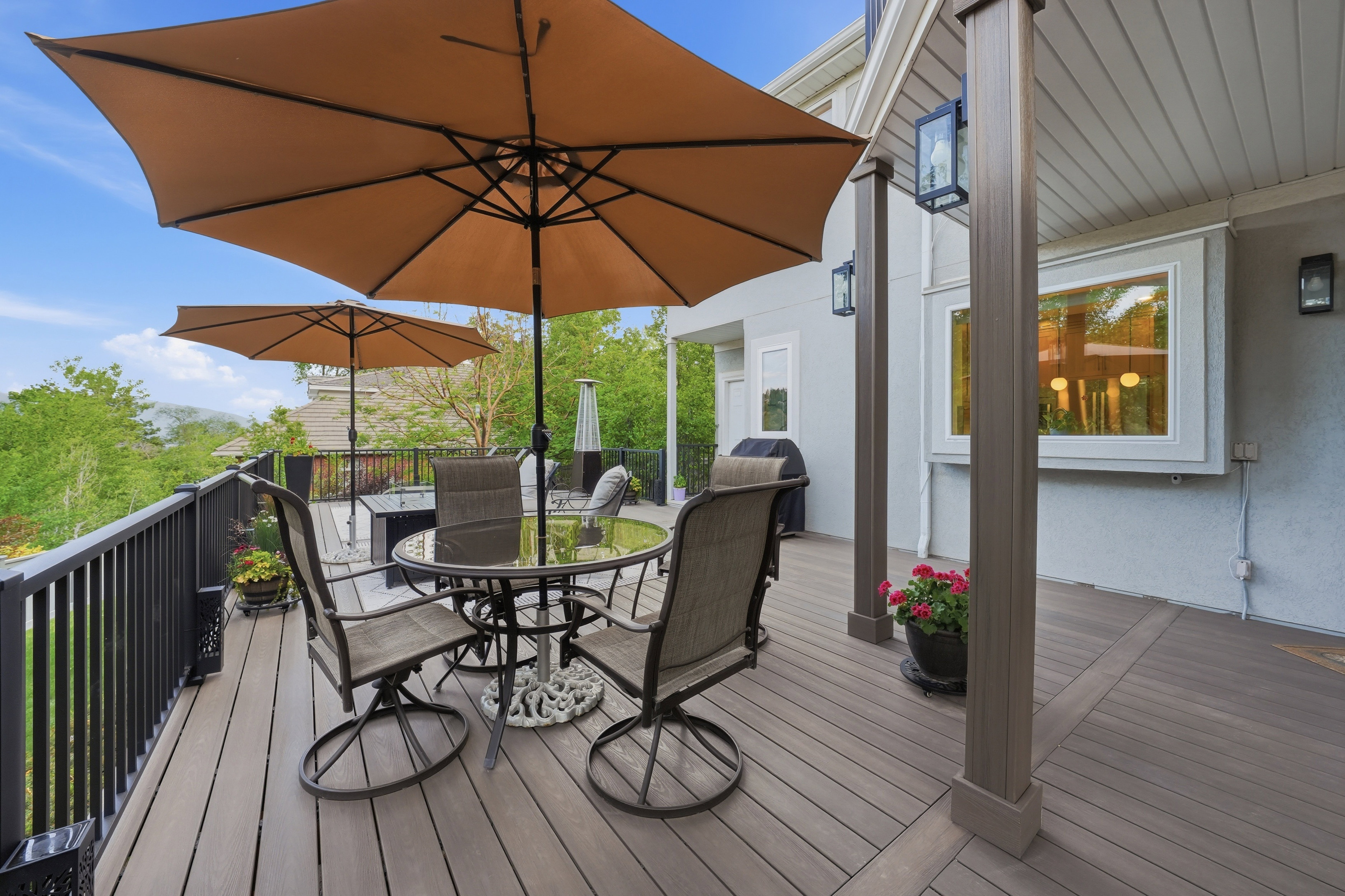 Spacious outdoor deck featuring composite decking, a black metal railing, and multiple support pillars