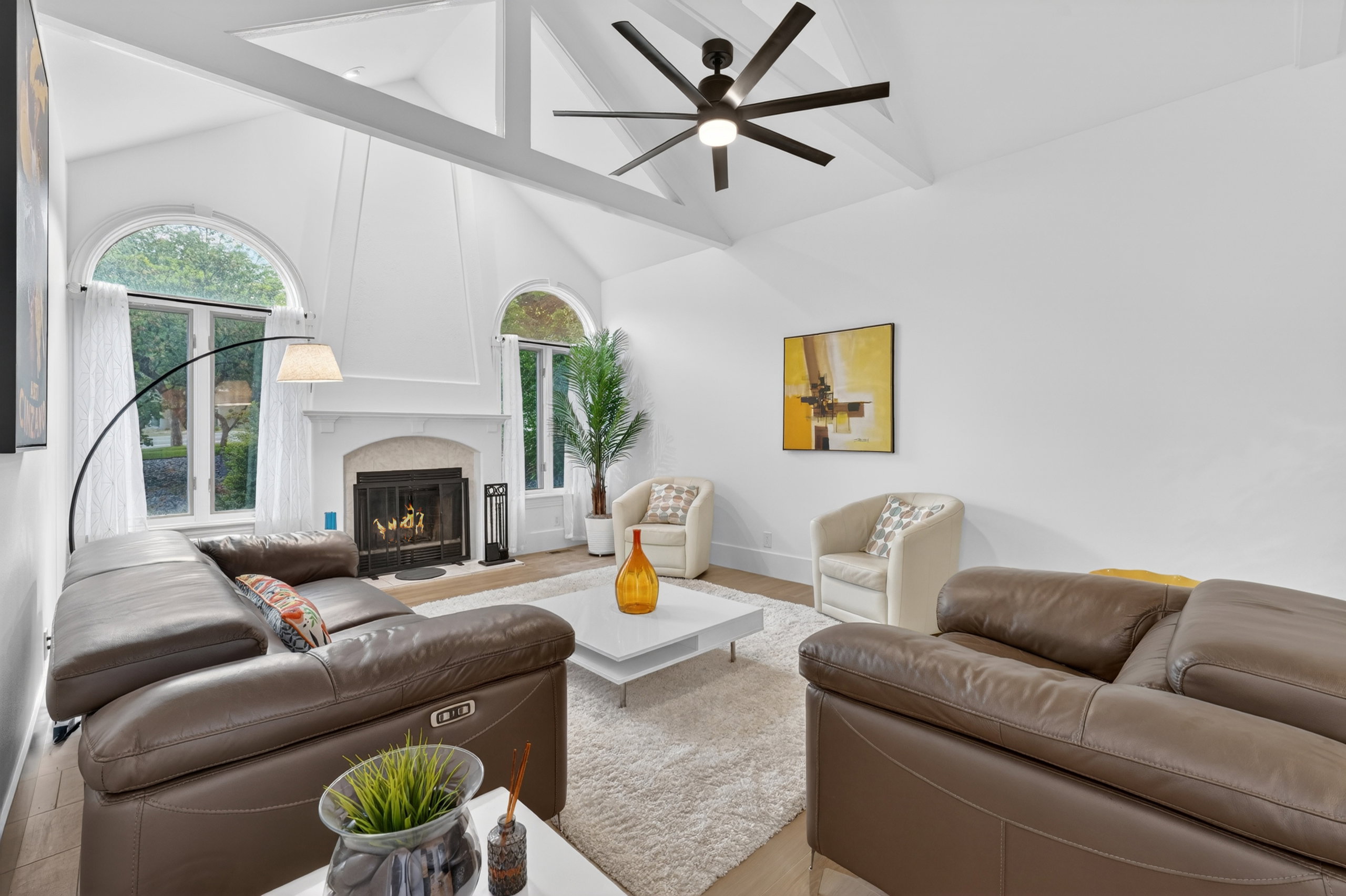 Vaulted ceilings with exposed white beams and a modern ceiling fan