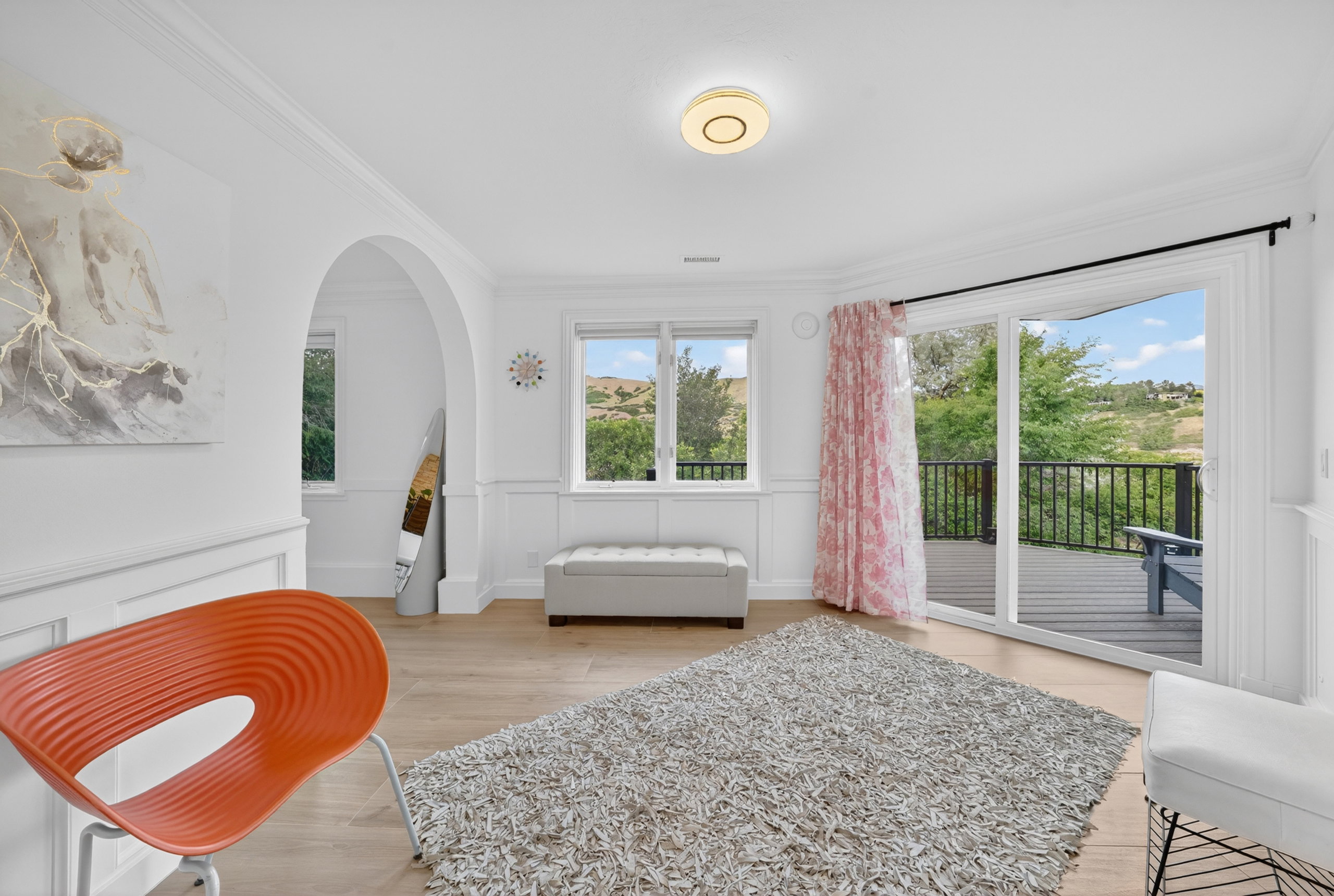 Spacious interior room with light wood-finish flooring, white wainscoting, and crown molding