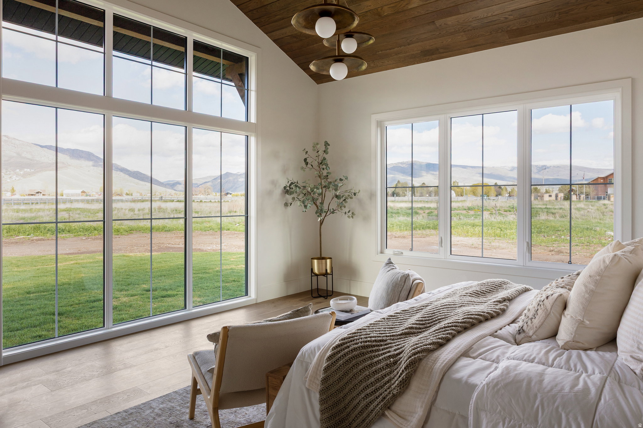 Primary bedroom suite on main level with expansive windows offering natural light & mountain views