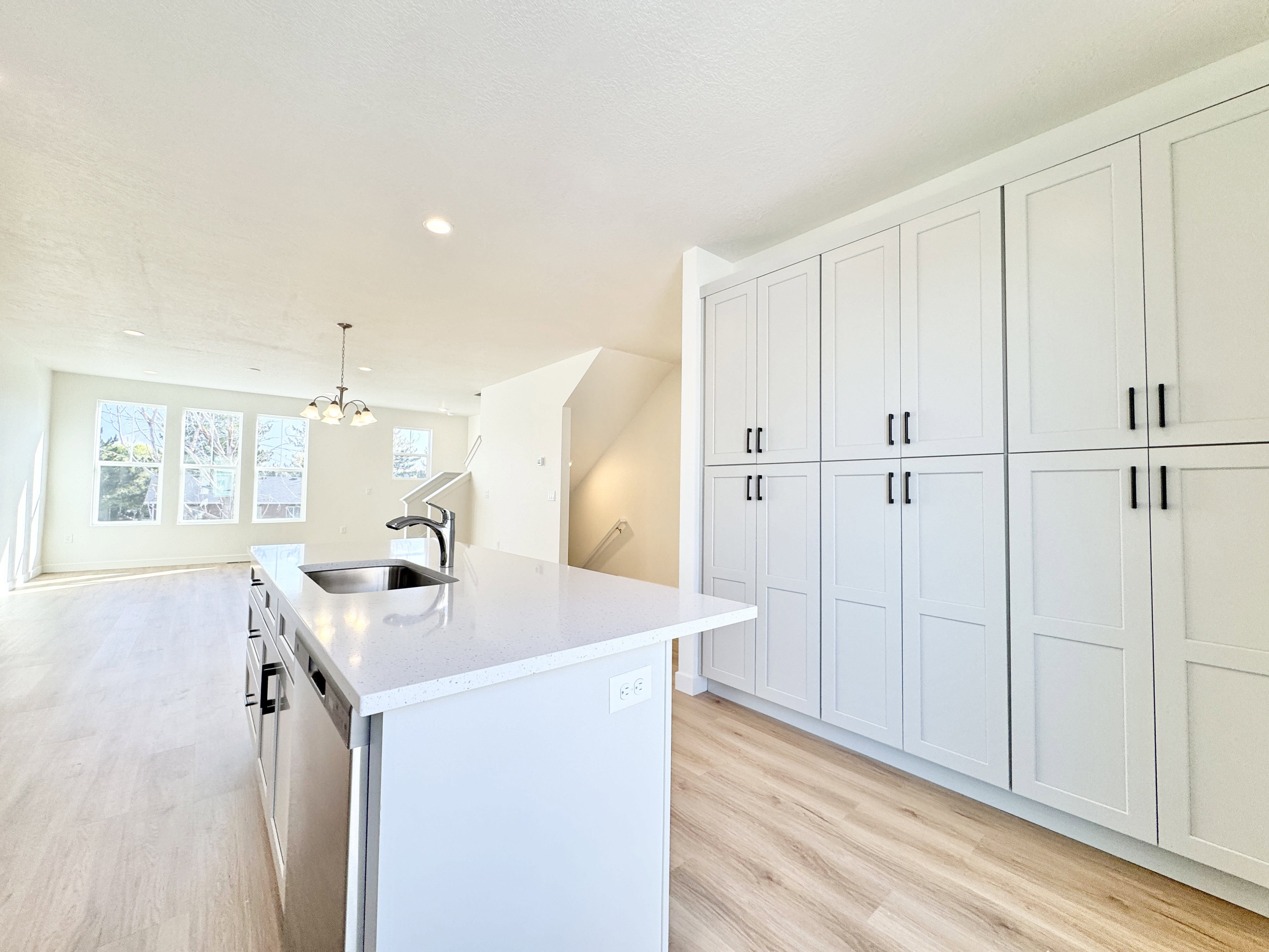 Modern kitchen featuring an island with an undermount sink, a sleek faucet, and a dishwasher