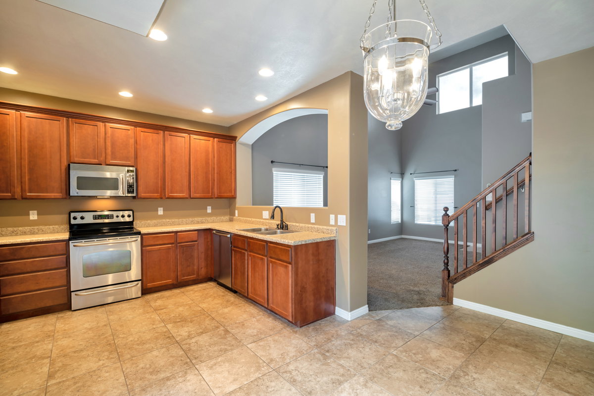 Well-appointed kitchen featuring wood cabinetry, stainless steel appliances, and a tile backsplash