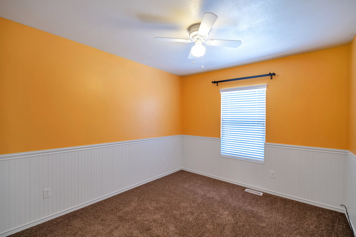 Room featuring wainscoting and warm orange-painted walls