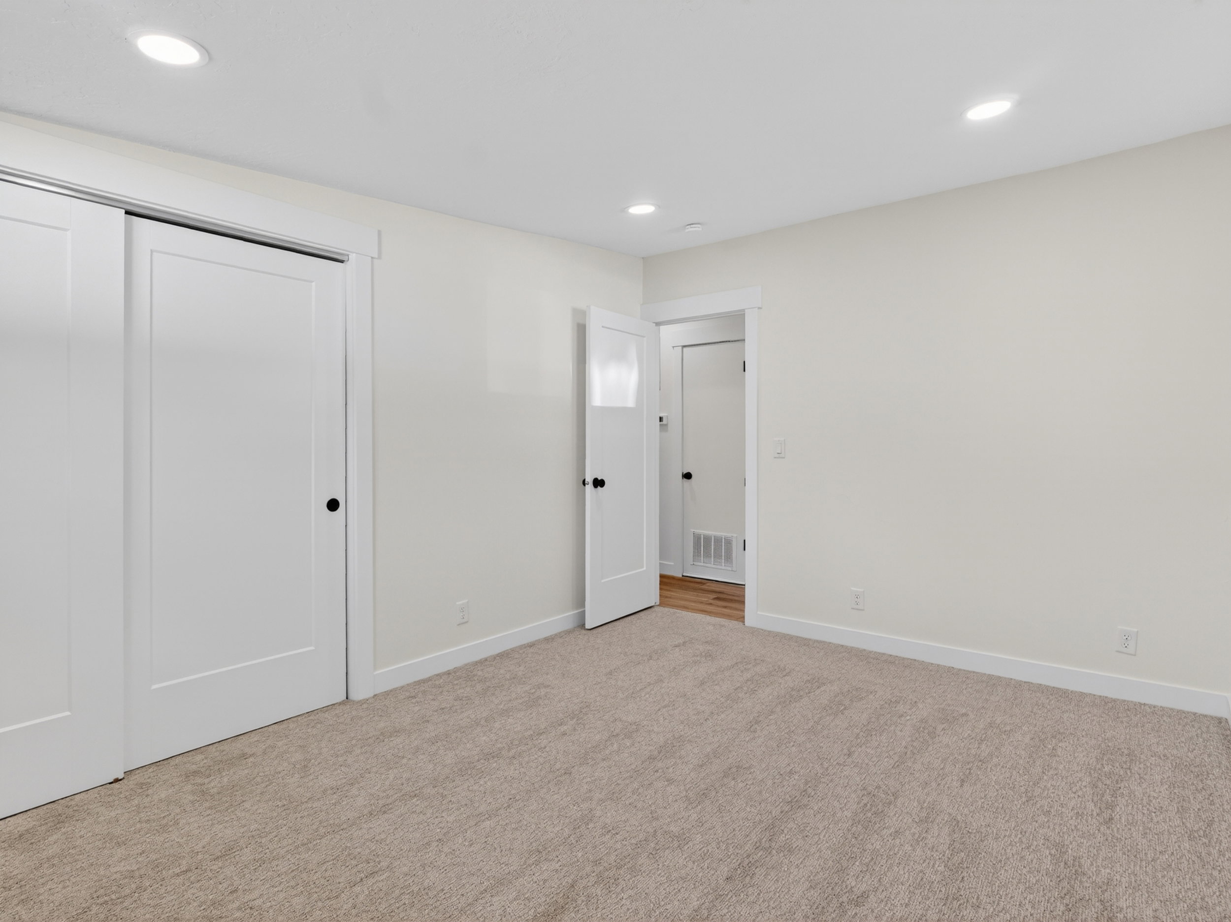 Neutral tone carpeting with white baseboards