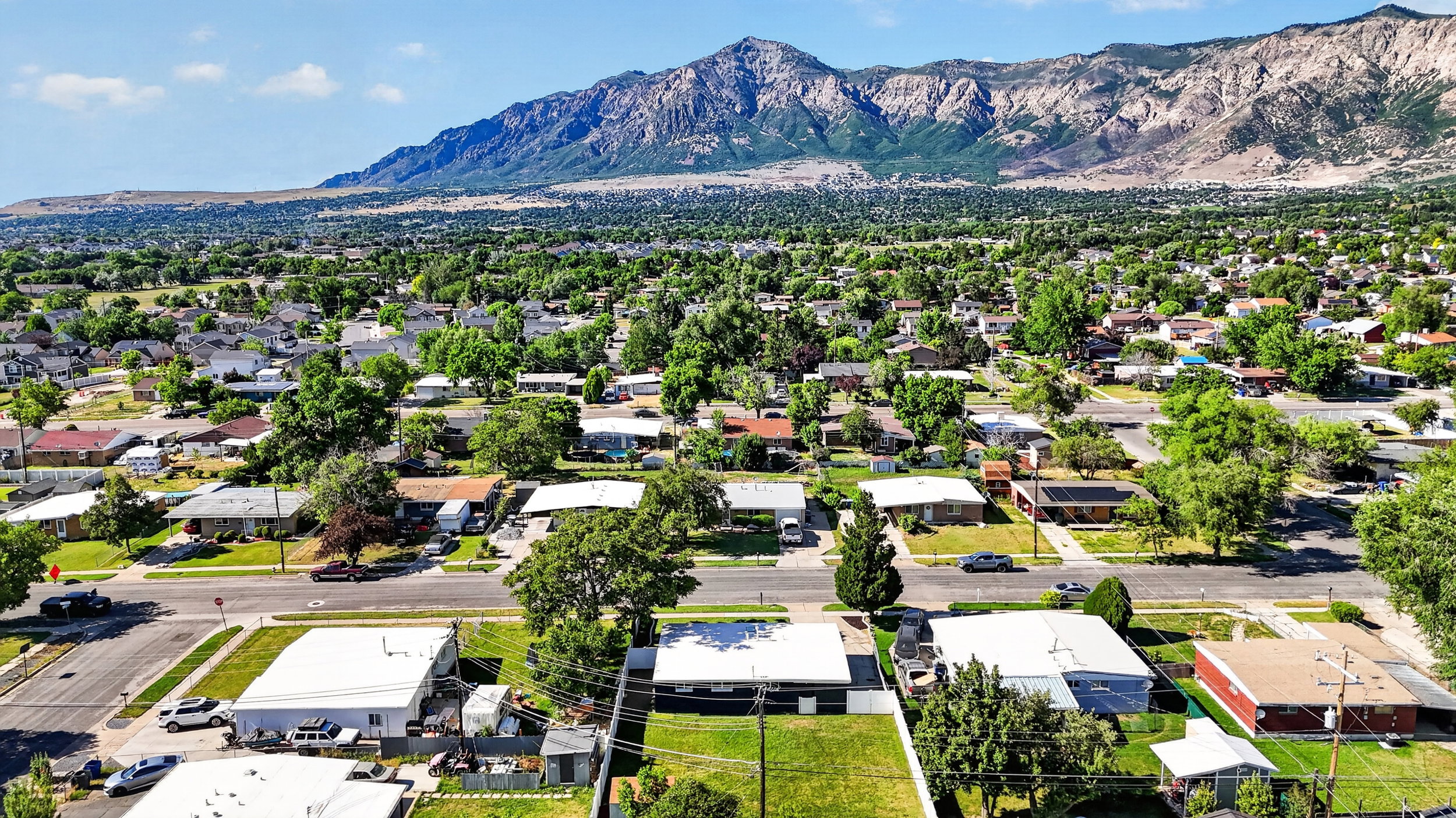 Expansive residential neighborhood featuring established homes and mature trees, set against a prominent mountain backdrop