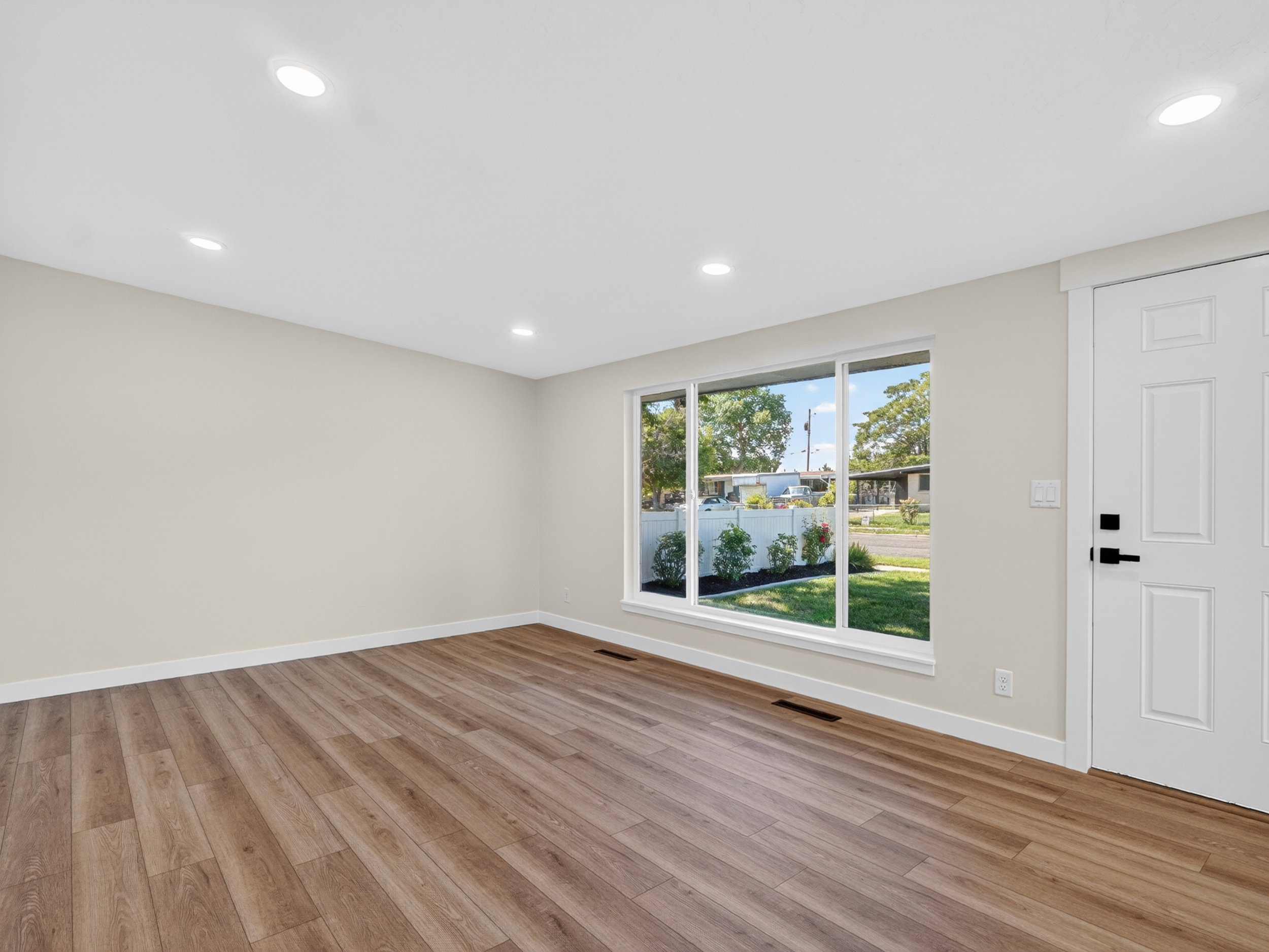 Spacious interior featuring wood-finish flooring, recessed lighting, and a large multi-pane window