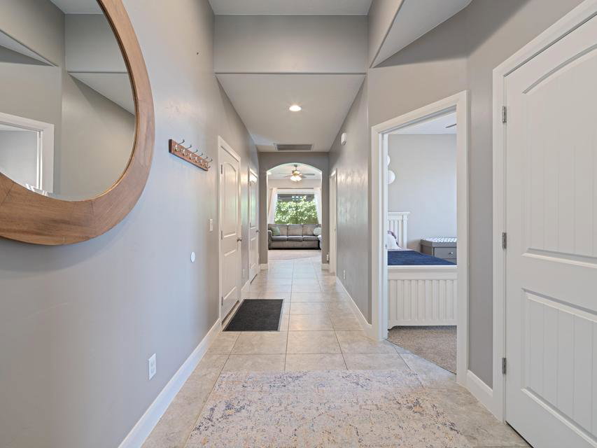 Hallway with neutral wall tones and tile flooring