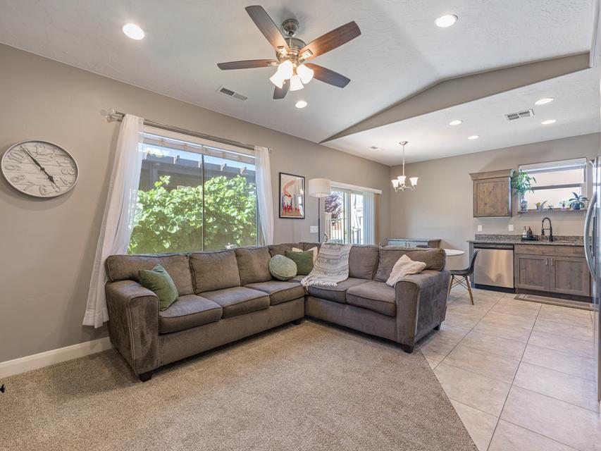 Open-concept living space featuring a ceiling fan, recessed lighting, and a large window