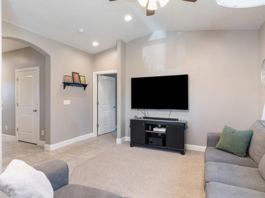 Living area featuring vaulted ceilings, recessed lighting, and a ceiling fan