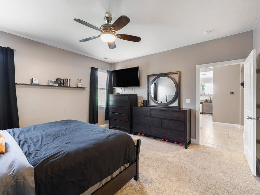 Carpeted room with a ceiling fan light fixture
