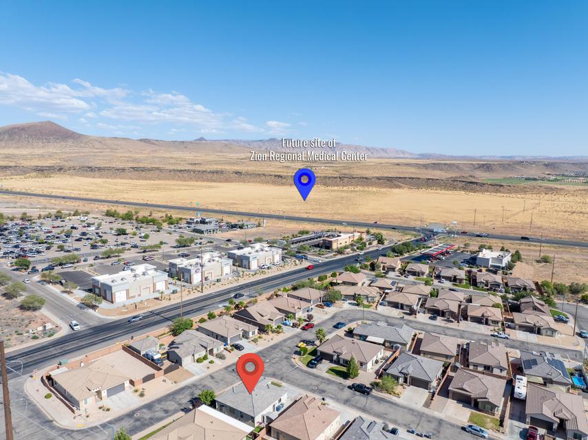 Aerial perspective showcasing a residential community with single-story homes, surrounded by desert landscapes and distant mountains