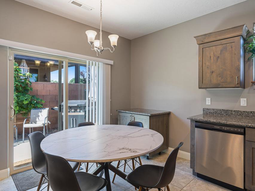 Dining area featuring a contemporary chandelier, a sliding glass door providing patio access, and tile flooring