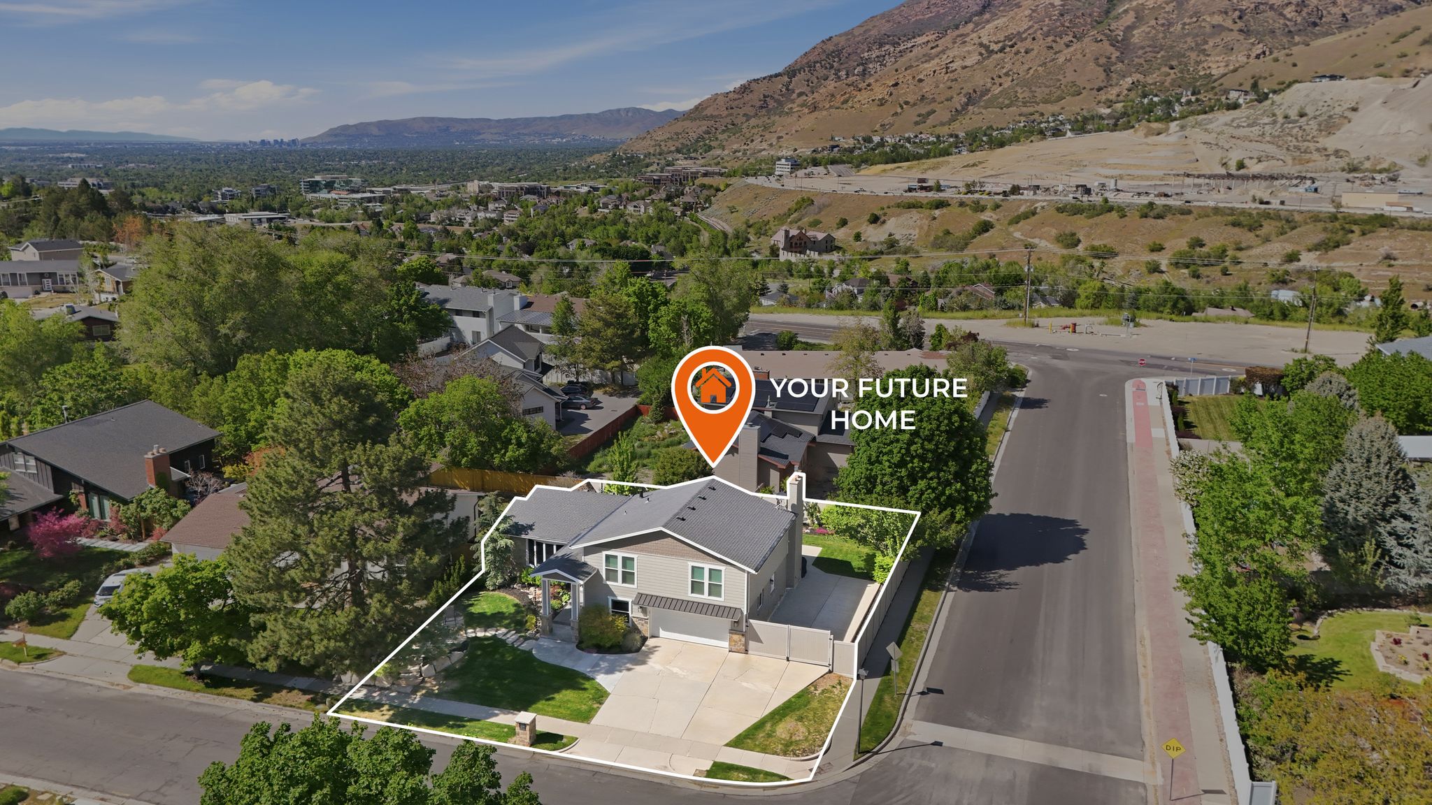 Aerial perspective showcasing the residential property with a multi-gabled roof, a paved driveway, and established landscaping