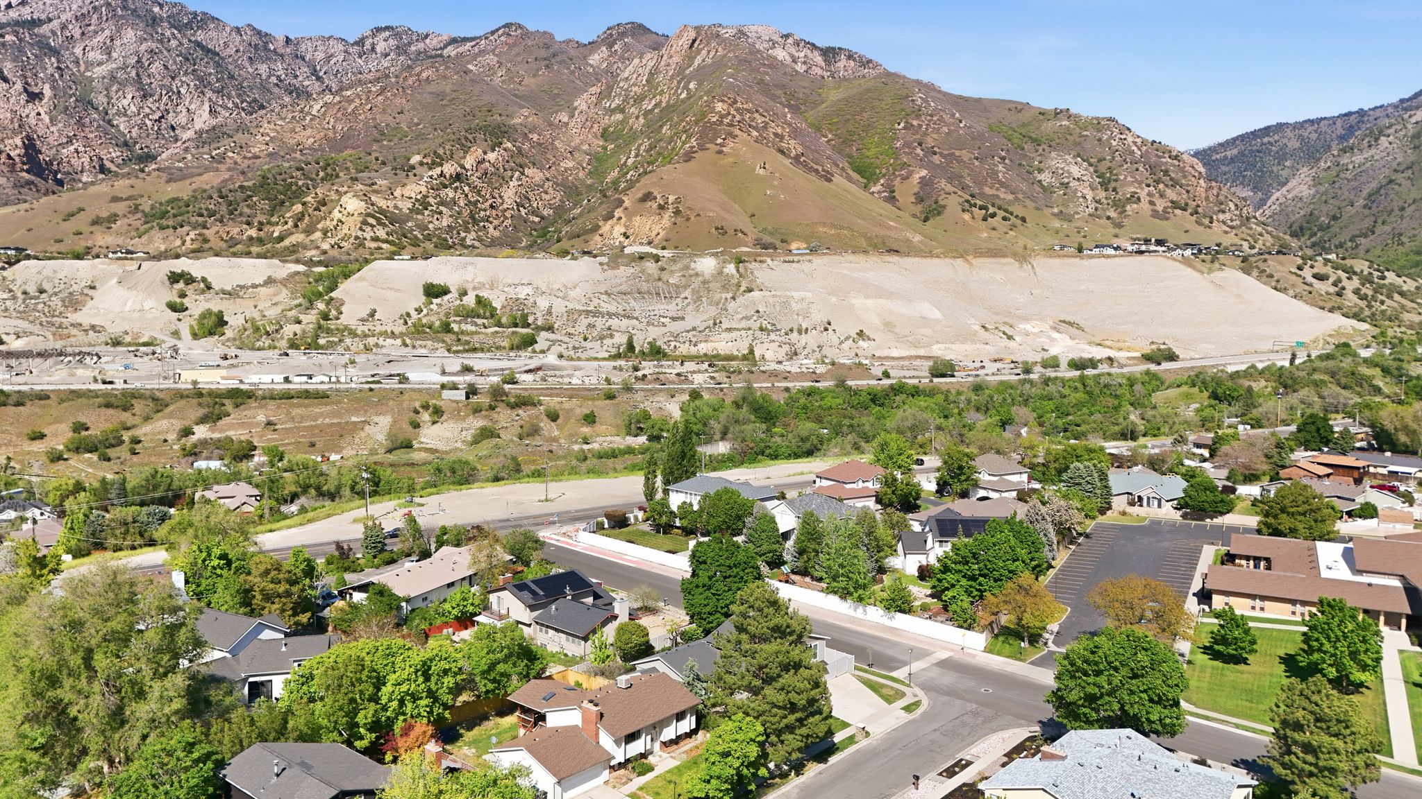 Elevated aerial perspective showcasing a residential neighborhood with surrounding natural mountain landscape