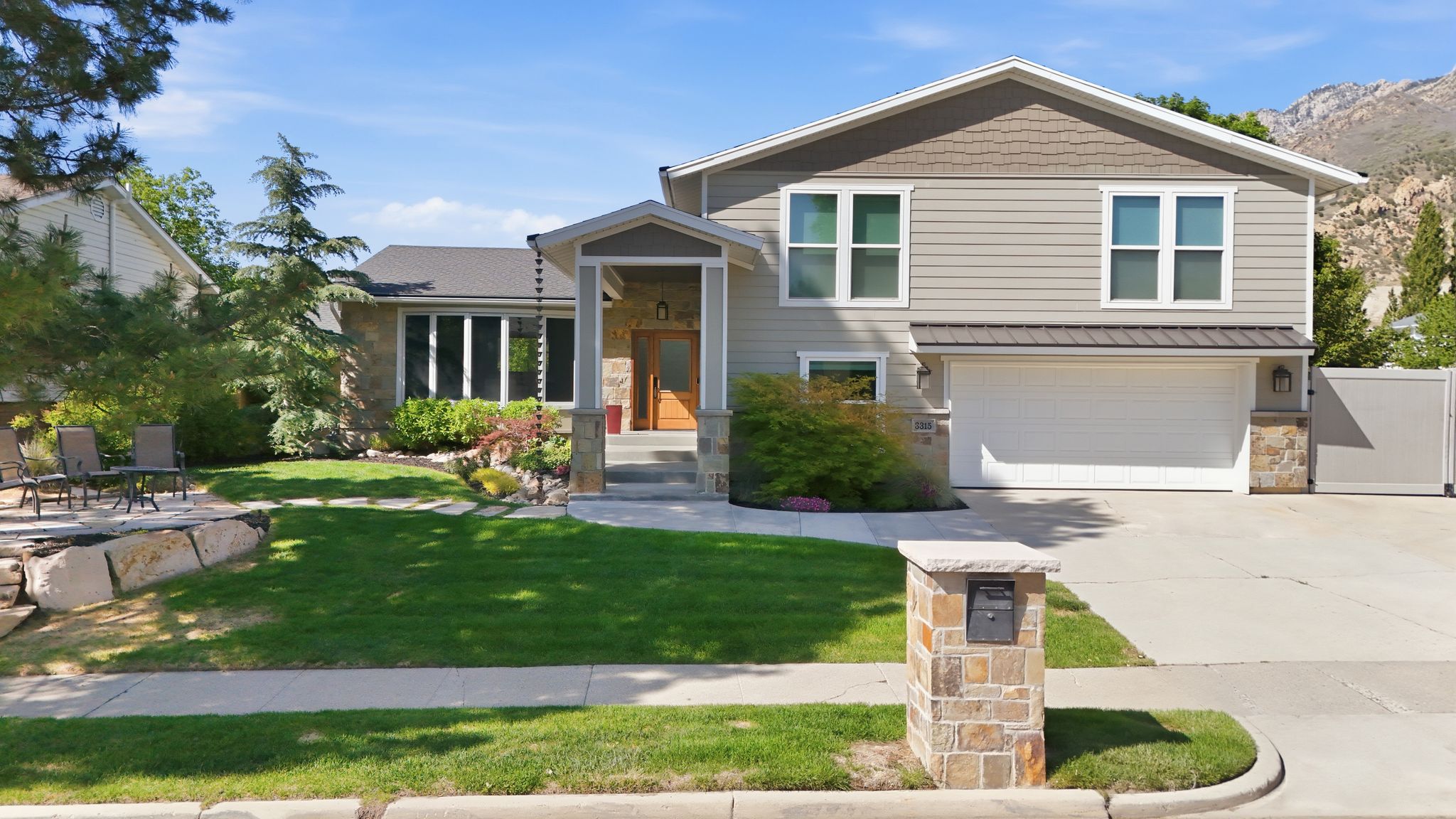 Contemporary exterior with stone accents and siding, featuring a covered front entry and a two-car garage with RV parking