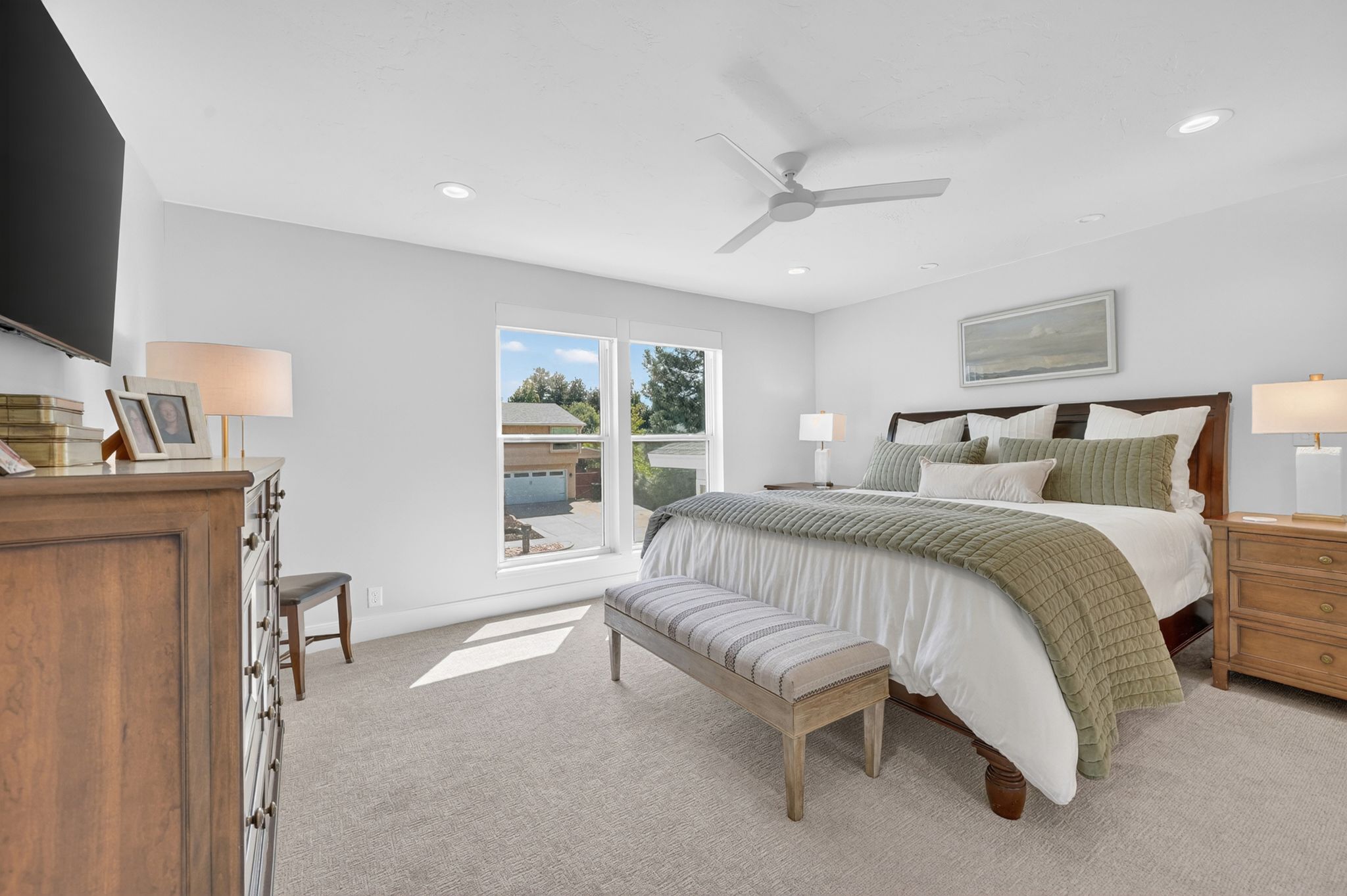 Spacious primary bedroom featuring light neutral walls, recessed lighting, a contemporary ceiling fan, and carpeted flooring with mountain views