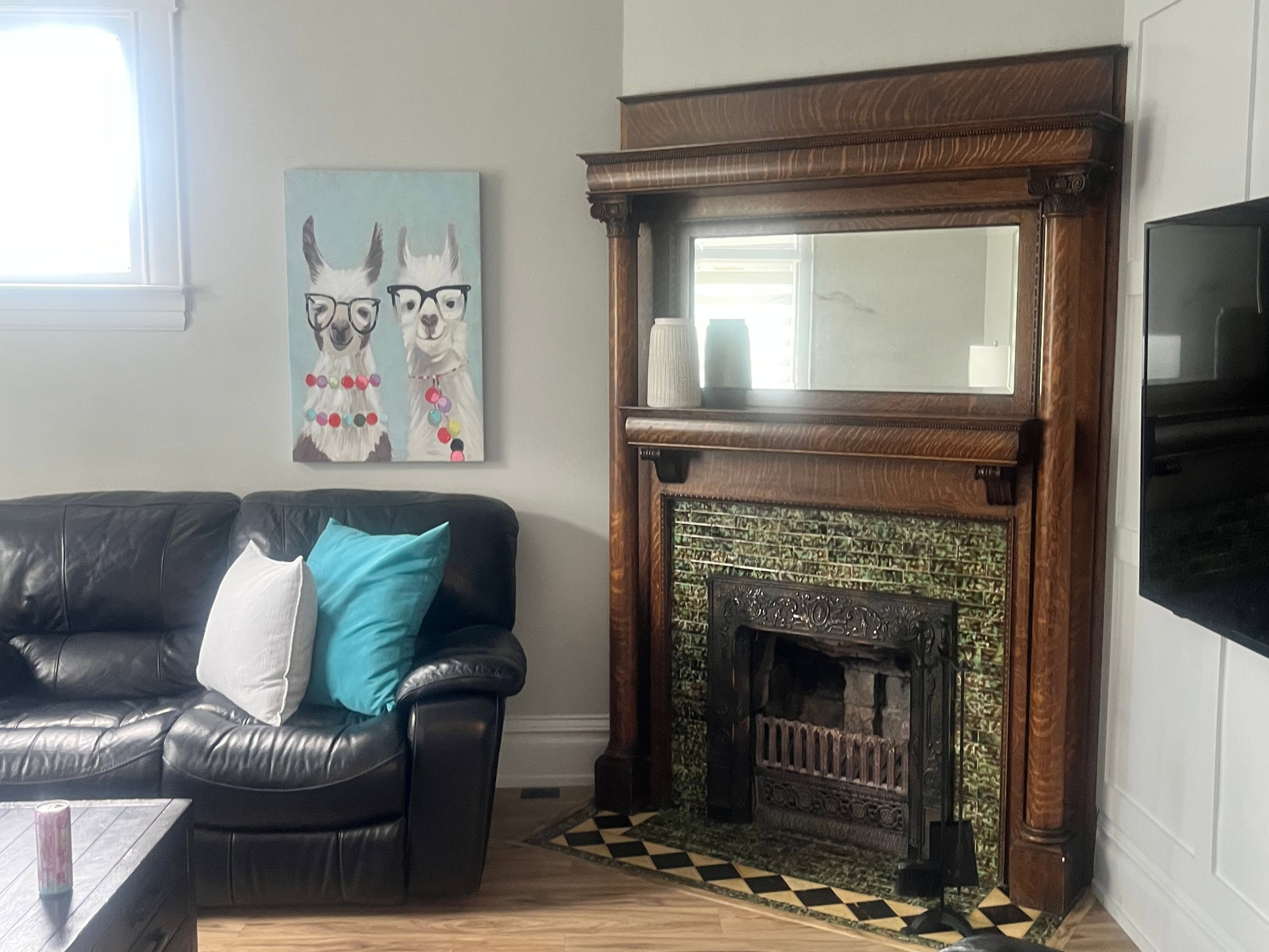 Decorative fireplace with green tile surround and dark wood mantel.