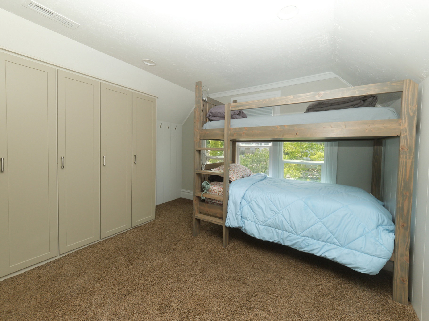 Built-in wardrobe cabinetry in a light neutral finish