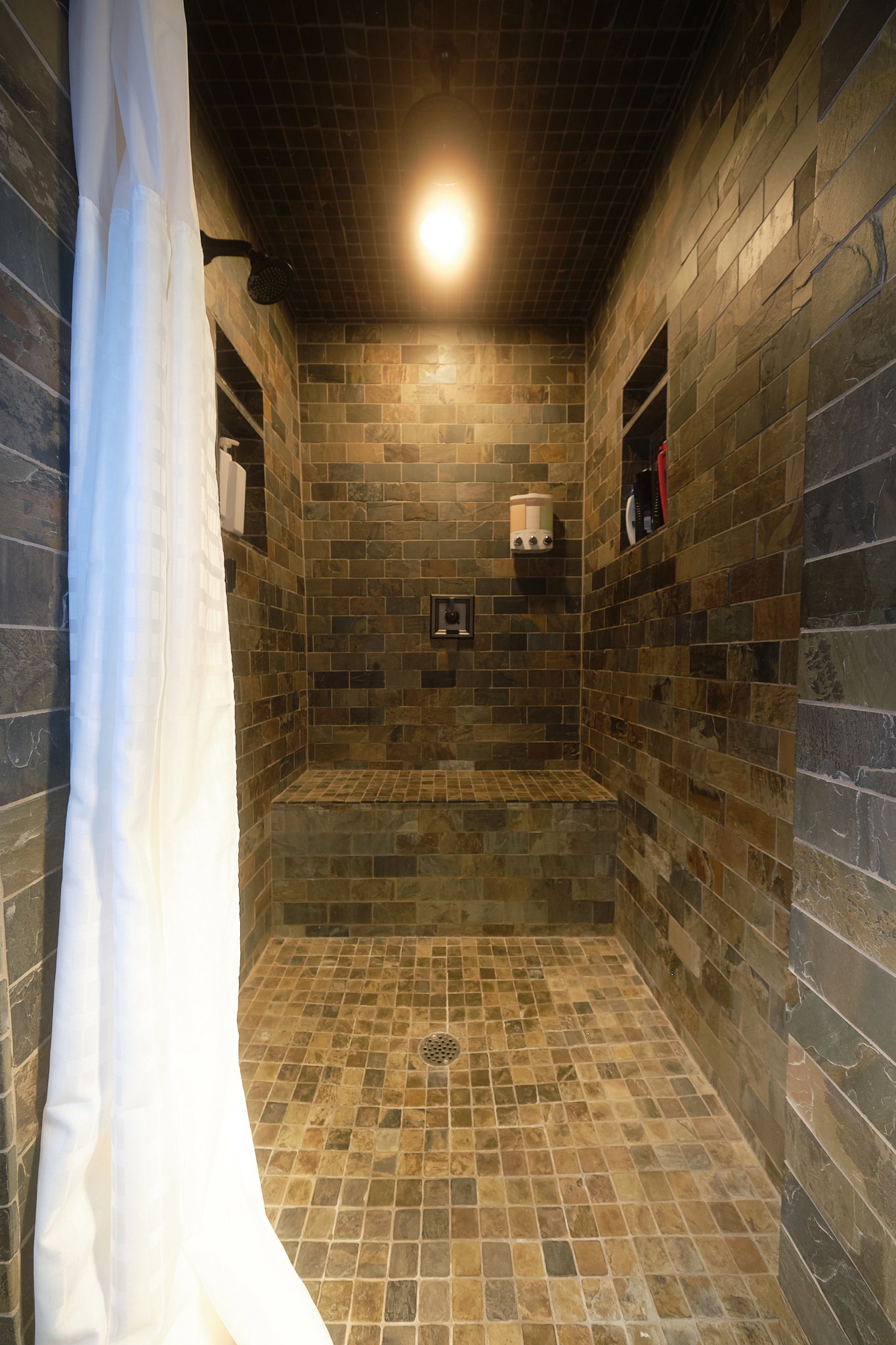 Brick pattern tiled shower, with arched doorway.
