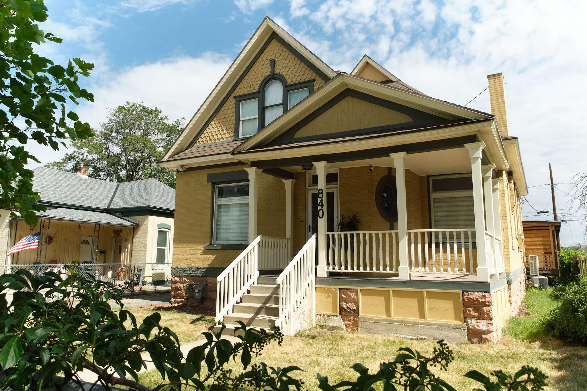 Victorian-style residence featuring a prominent front porch with white railings and columns