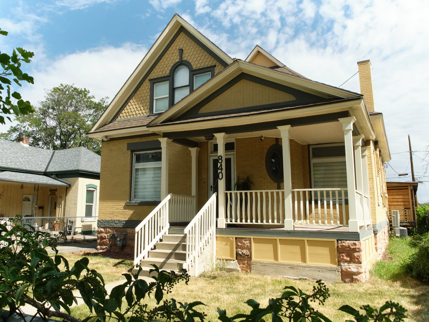 Victorian-style residence featuring a prominent front porch with white railings and columns