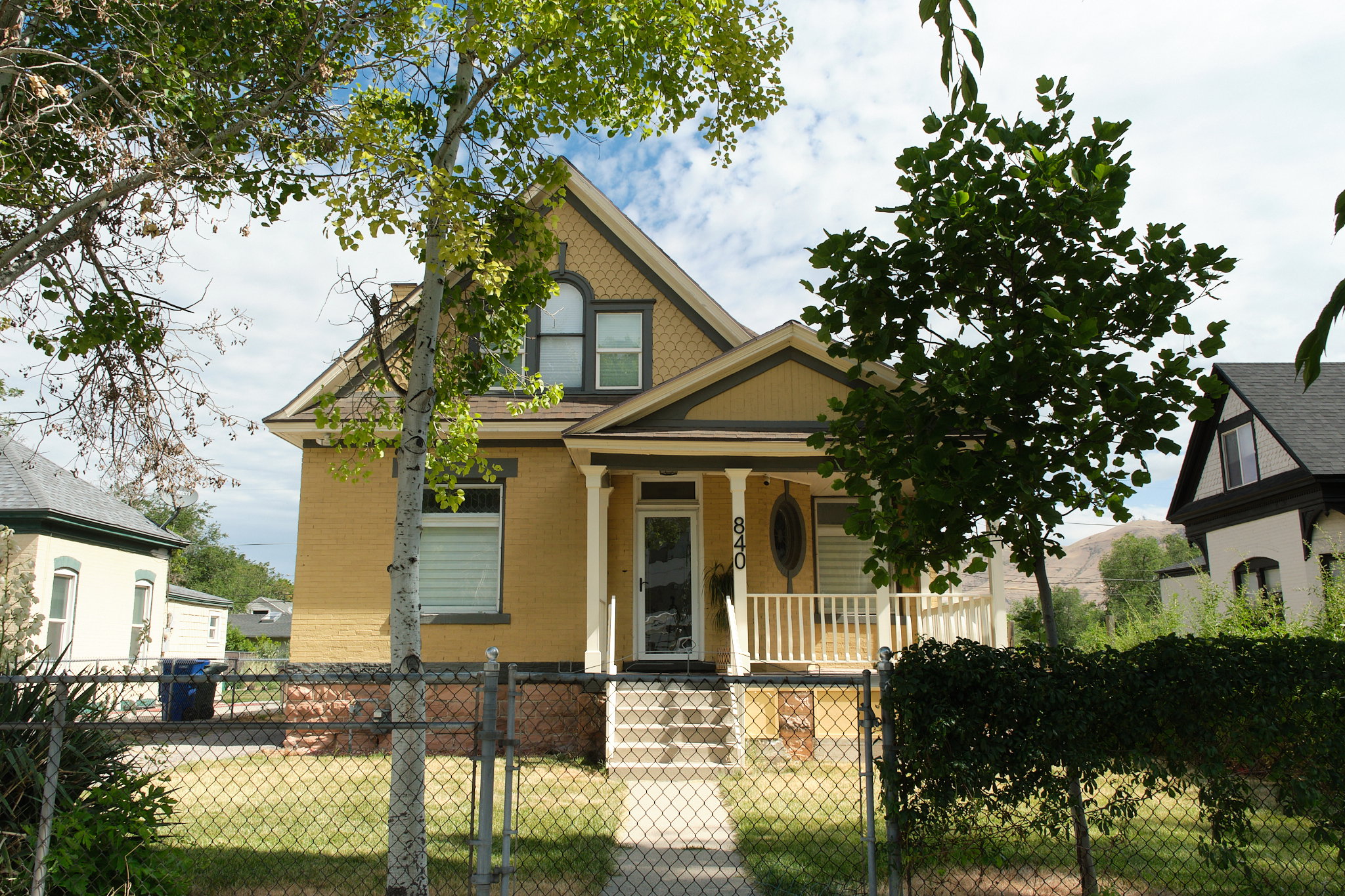 Yellow brick exterior featuring a covered porch with white columns