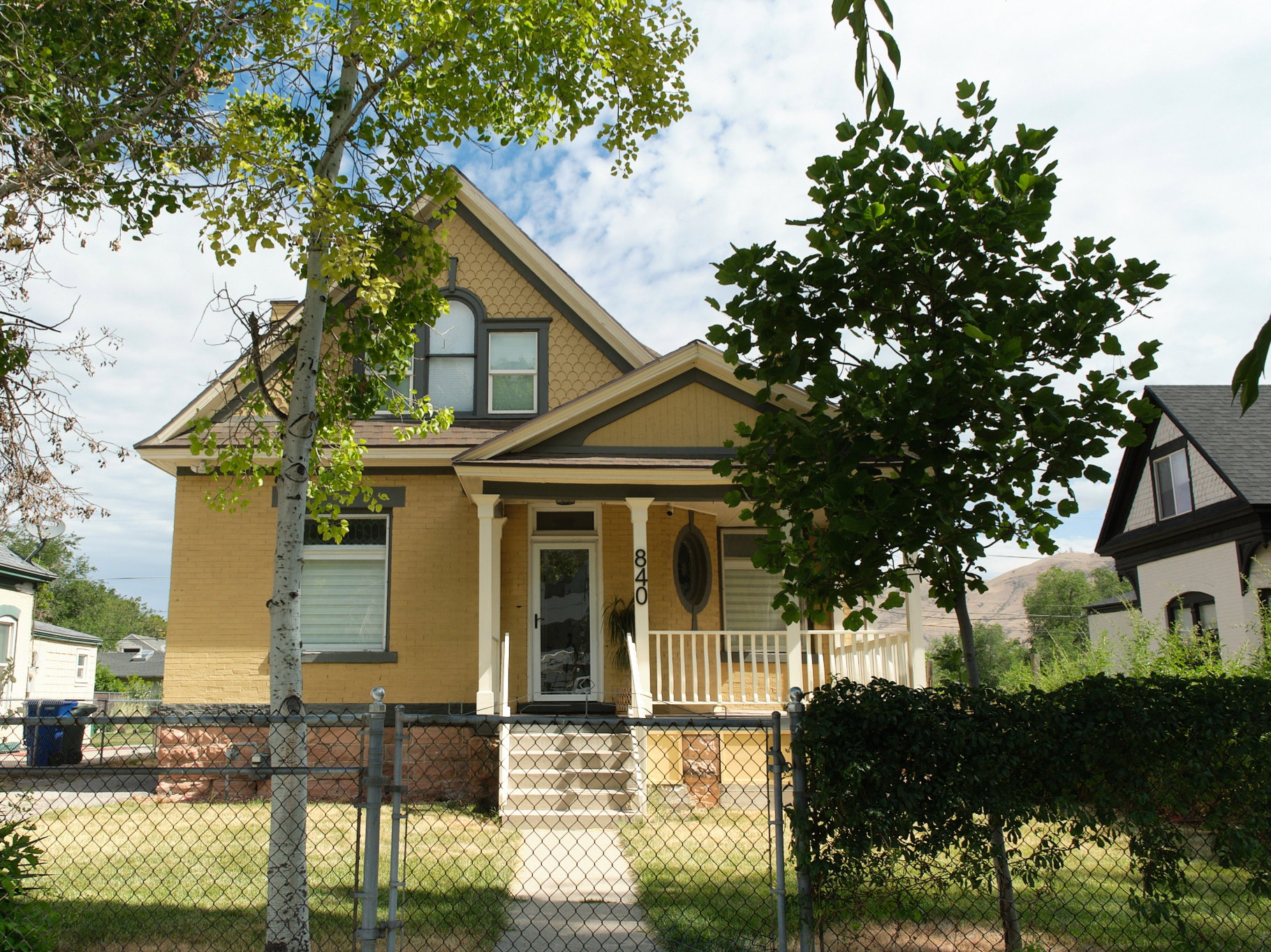 Yellow brick exterior featuring a covered porch with white columns