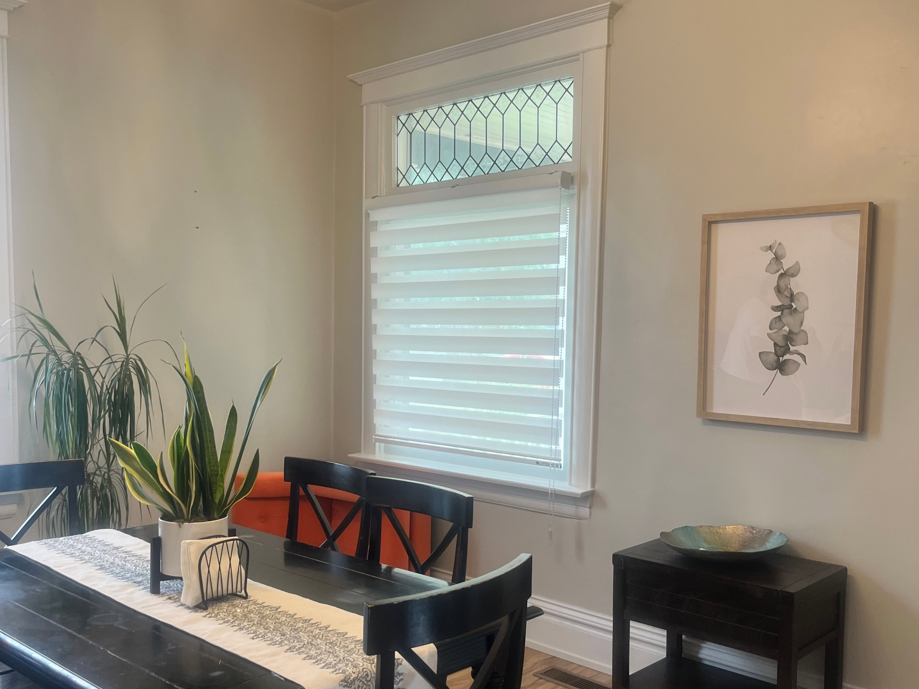 Dining area featuring wood-finish flooring, a decorative transom window with patterned glass.