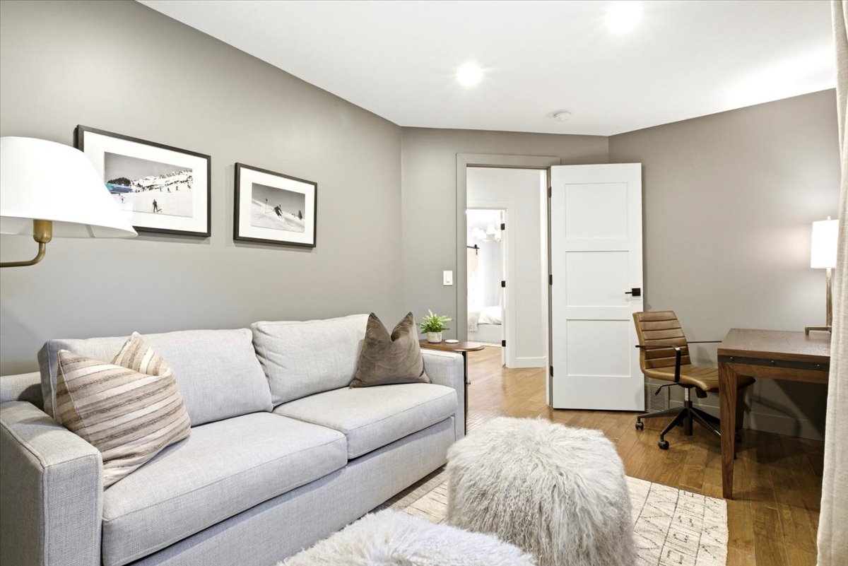 Versatile room featuring light wood-finish flooring, recessed lighting, and a modern three-panel interior door