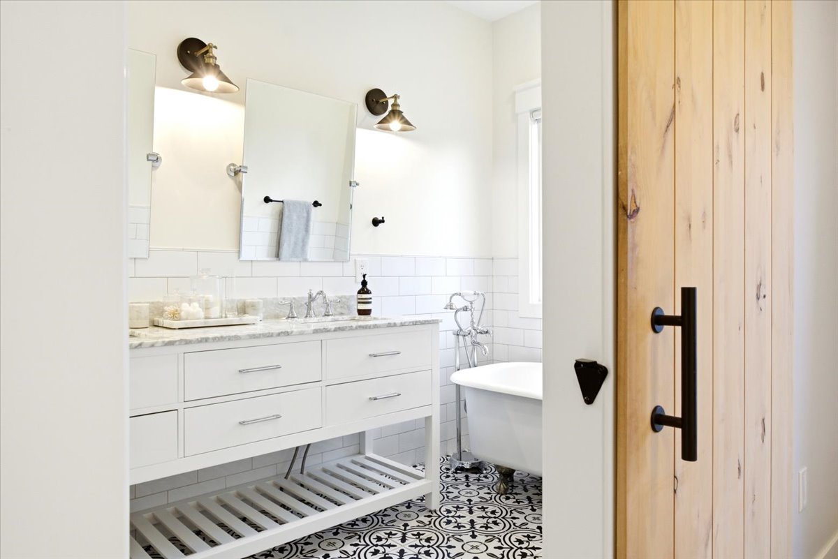Bathroom featuring a double vanity with white cabinetry and a light-toned countertop