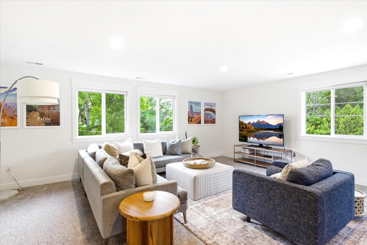 Light-filled living area featuring recessed lighting, a neutral color palette, and multiple windows with white trim