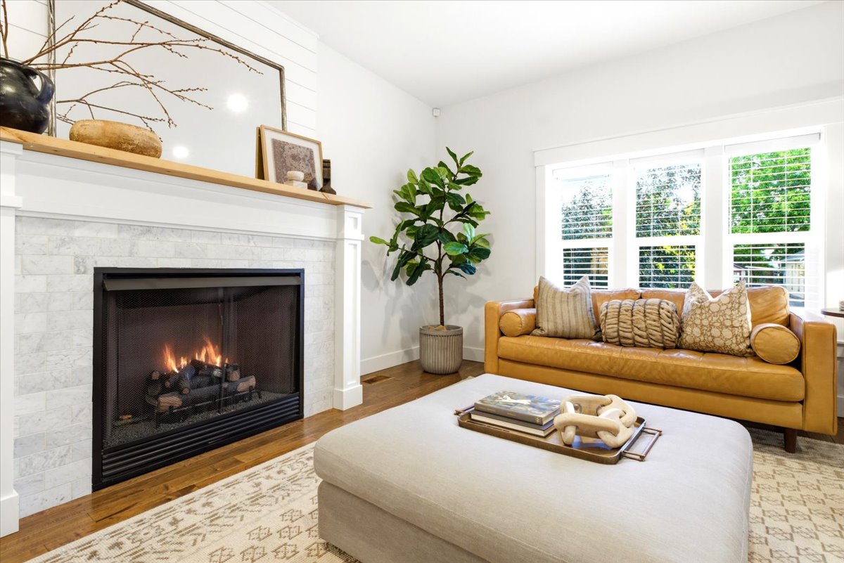 Living area featuring a fireplace with a light-toned stone surround, a white mantel, and a natural wood-finish top