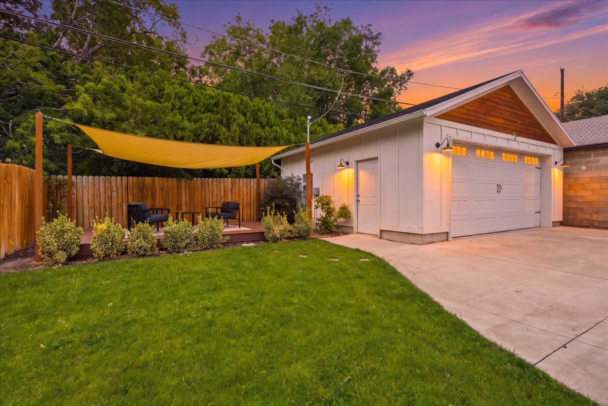Detached garage with a wood-finish gable accent, featuring a two-car garage door and separate pedestrian entry