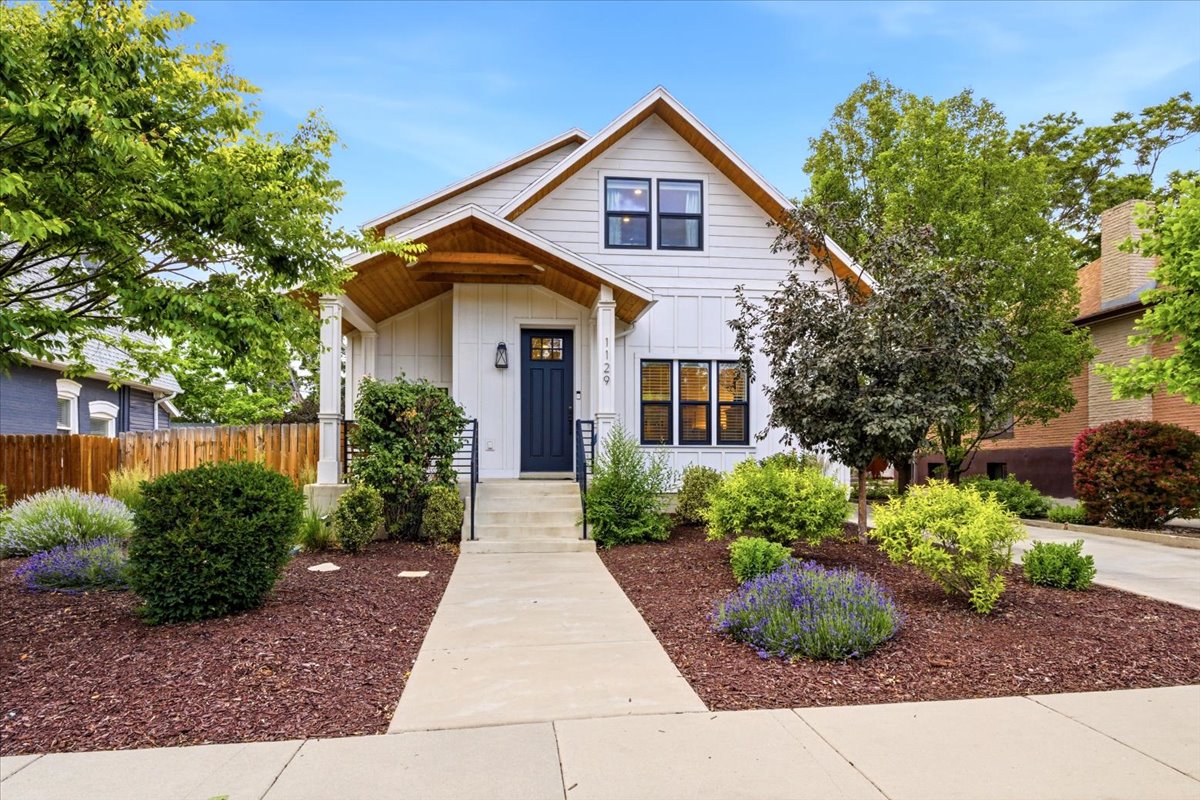 Modern farmhouse exterior with white siding and a dark blue entry door