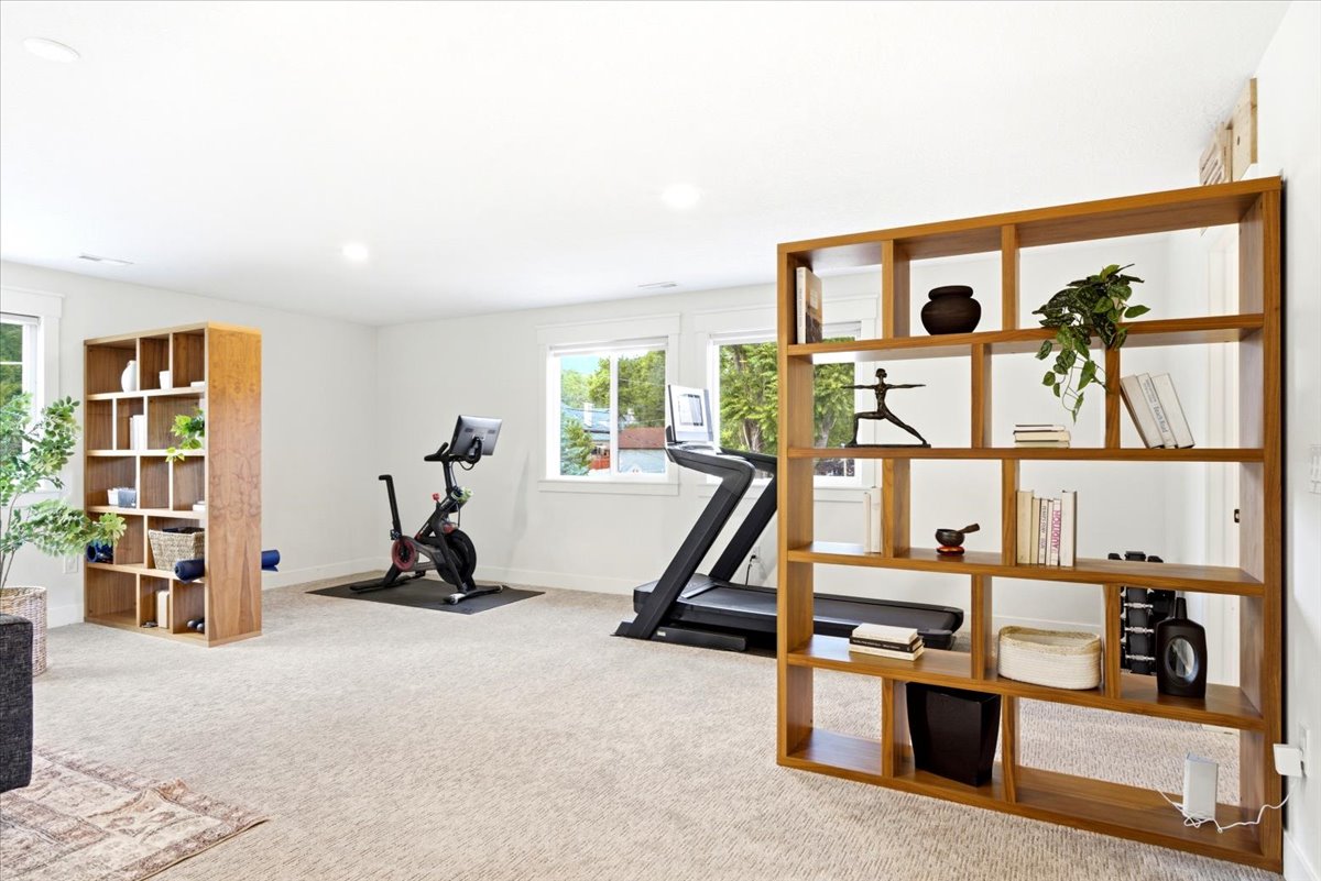 Spacious room featuring light-colored carpeting, recessed lighting, and multiple windows
