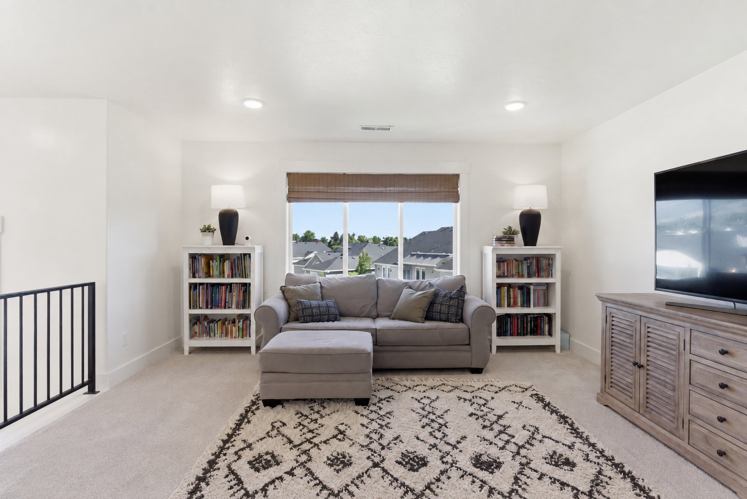 Upper-level living area with carpeted flooring and recessed lighting