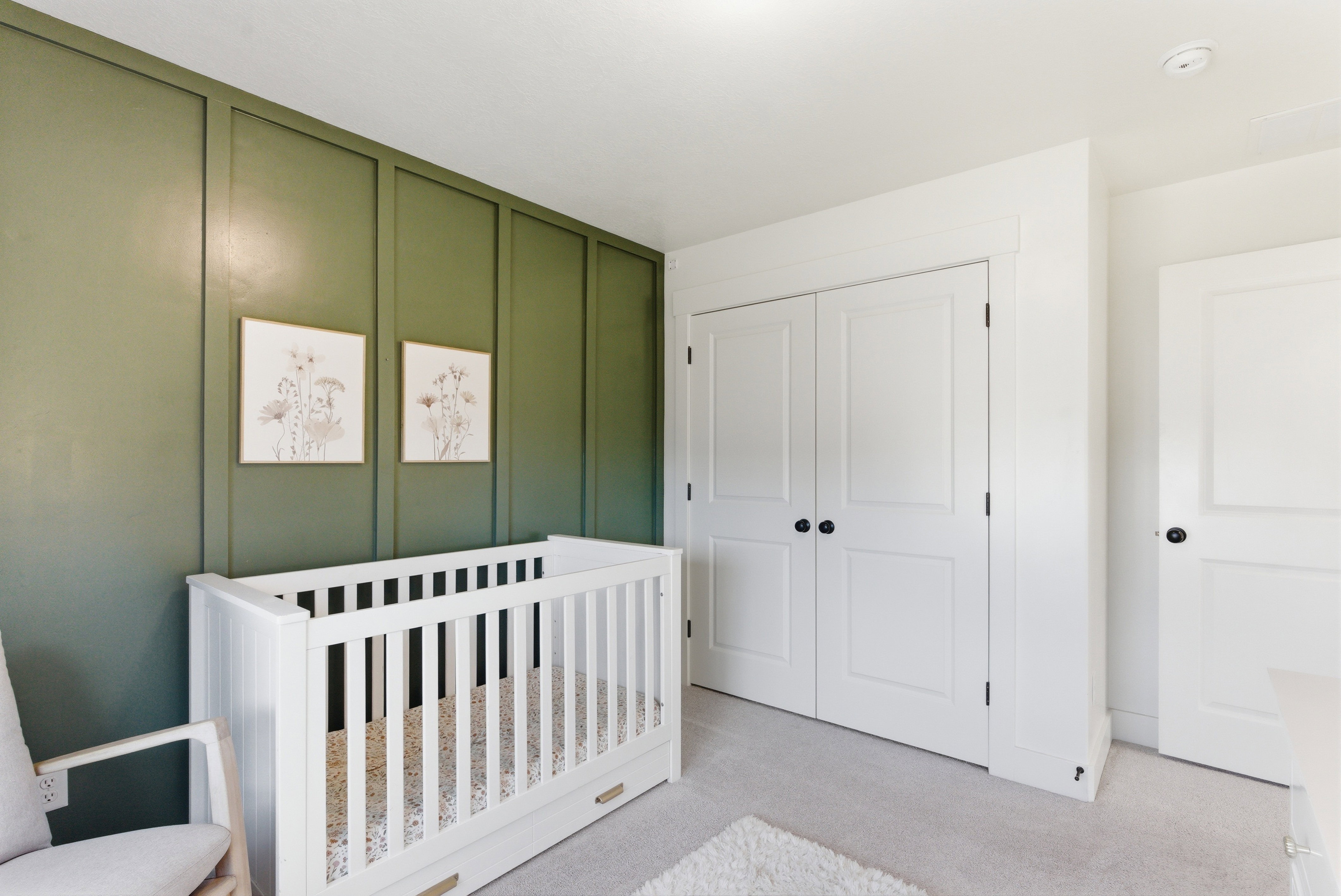 Room featuring a striking green accent wall with vertical paneling, providing a distinct architectural detail
