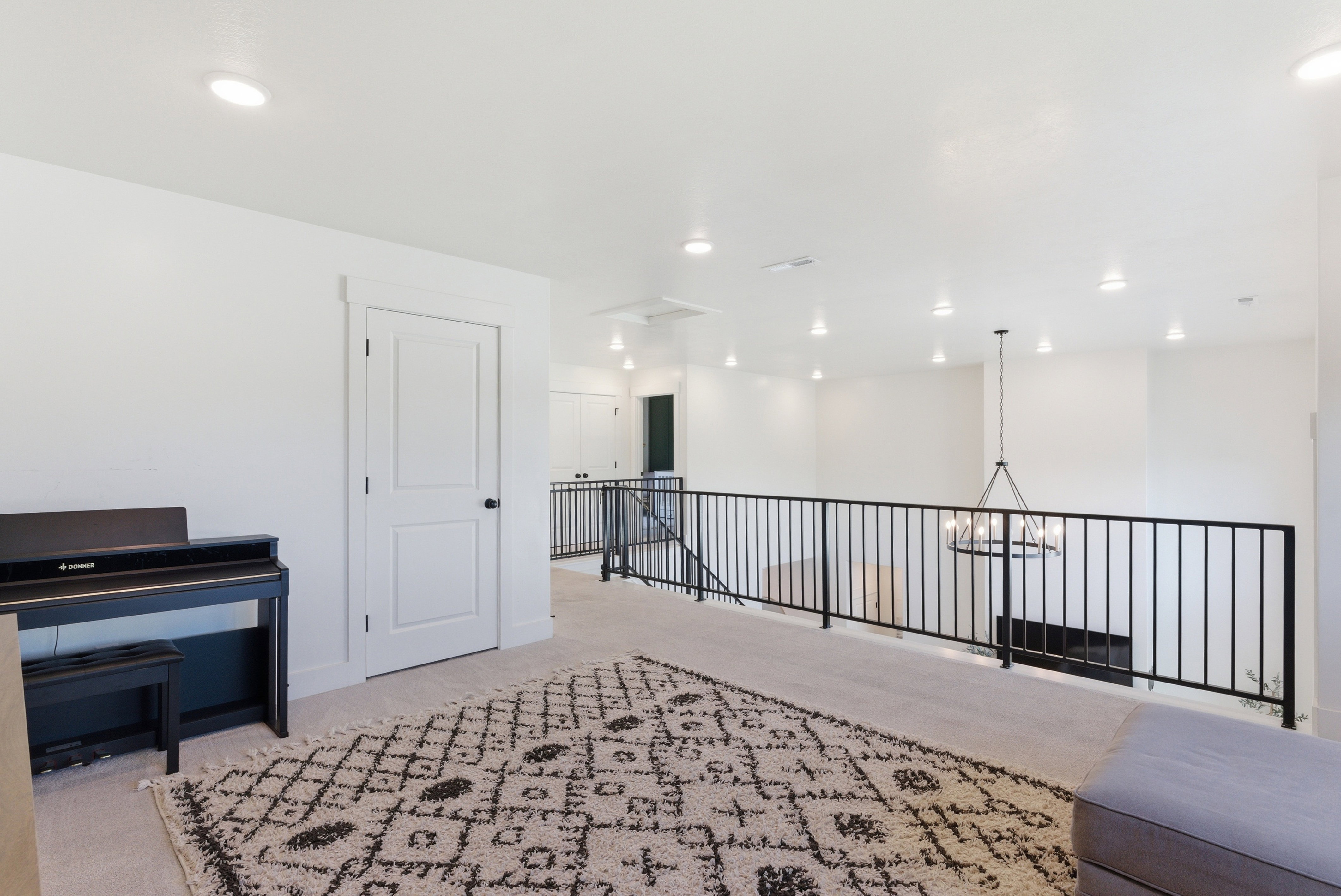 Spacious loft area featuring light-toned carpeting and recessed lighting