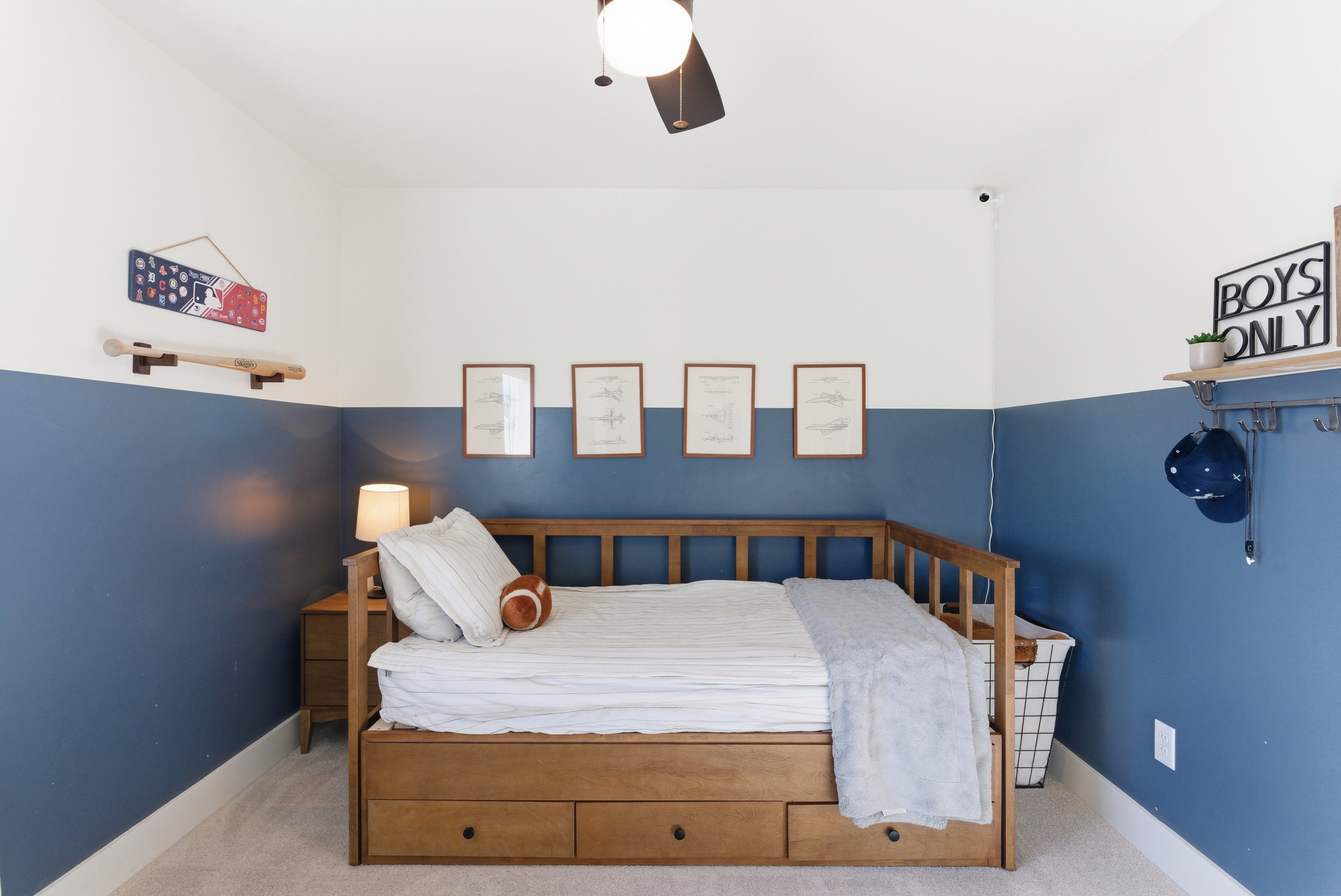 Room featuring two-tone walls, light-colored carpeting, a ceiling fan with integrated lighting, and white baseboards