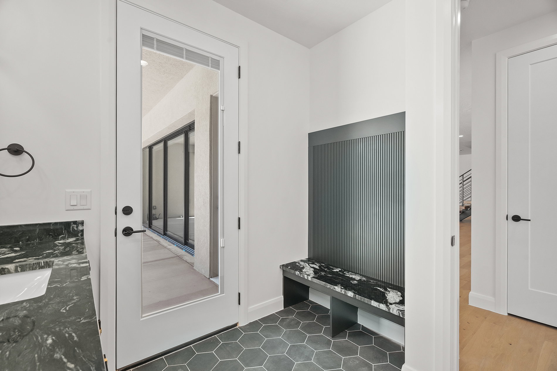 Pool Bathroom. Vanity with dark cabinetry and stone countertop
