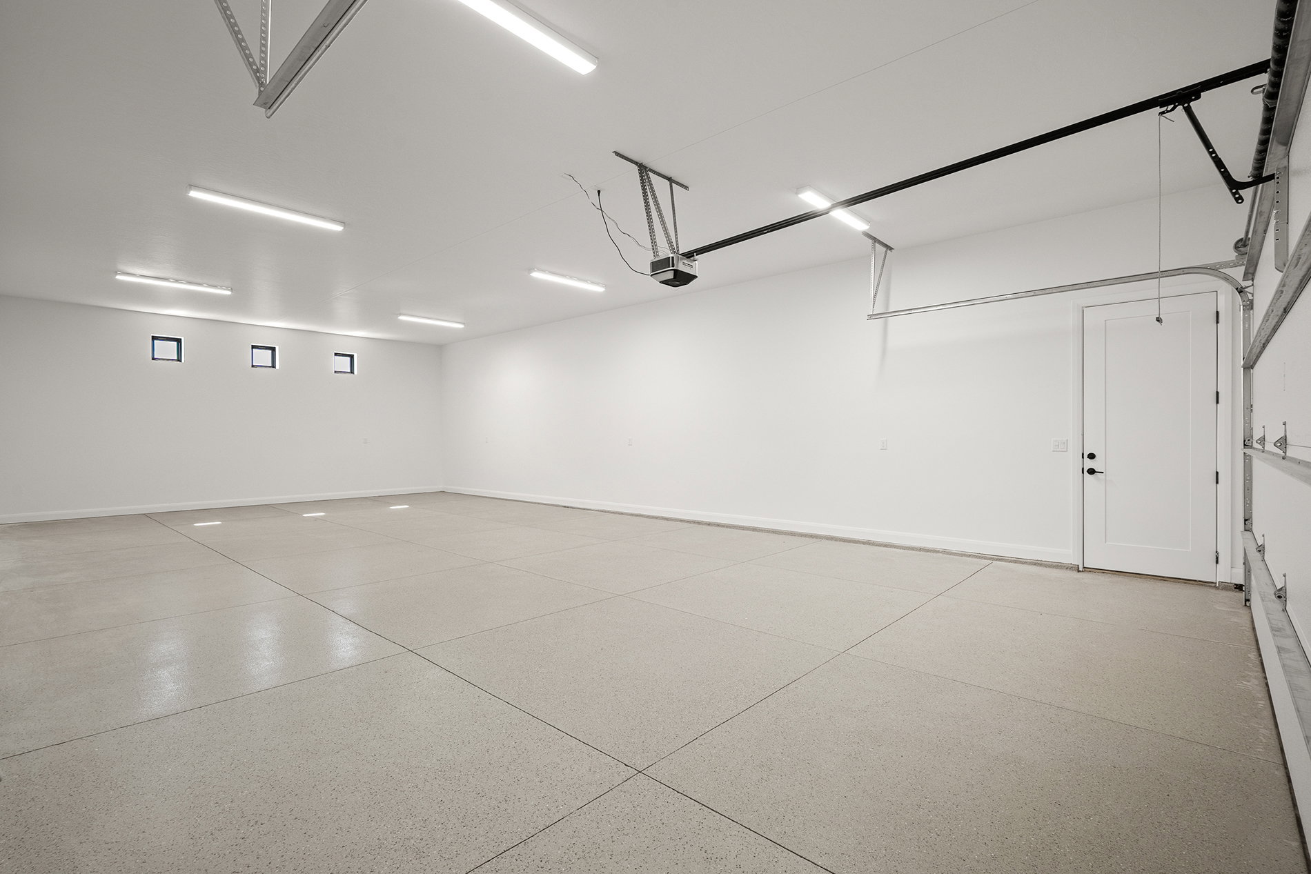 Spacious garage with epoxy-coated concrete flooring