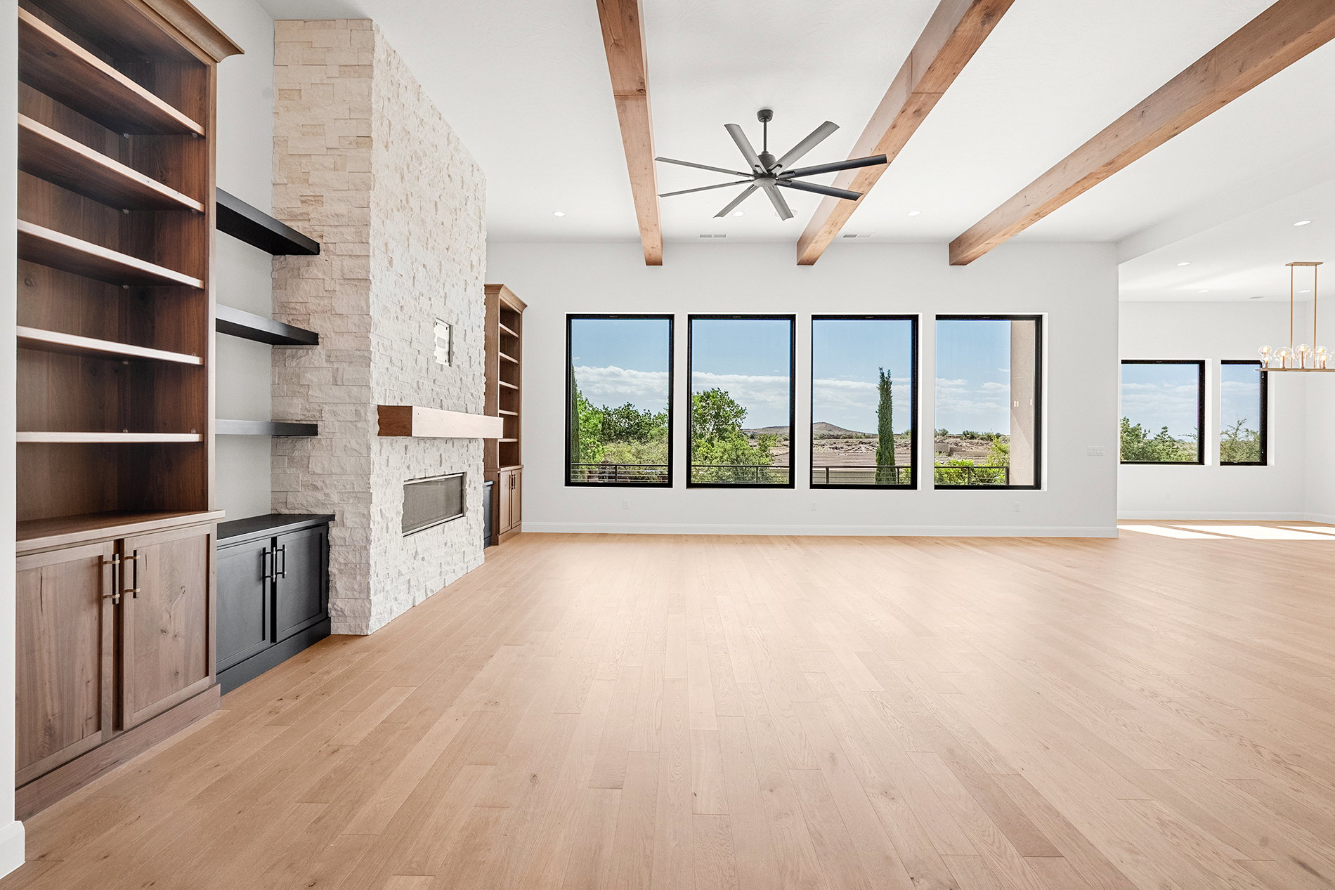 Expansive living space featuring wood-finish flooring and exposed ceiling beams