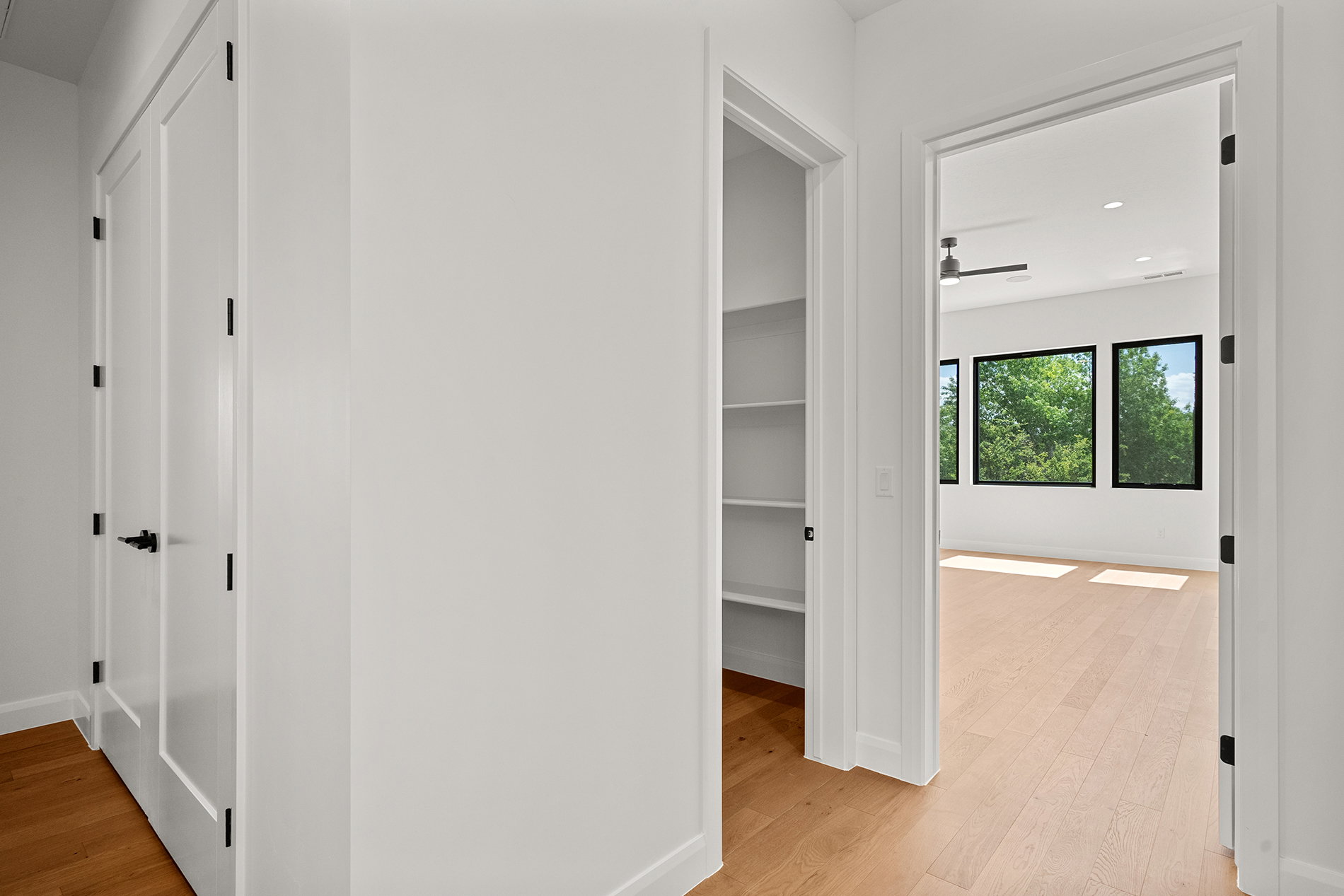 Open doorway revealing an interior room with light wood-finish flooring
